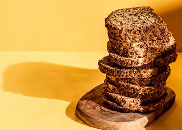 a stack of sliced bread on a wooden cutting board