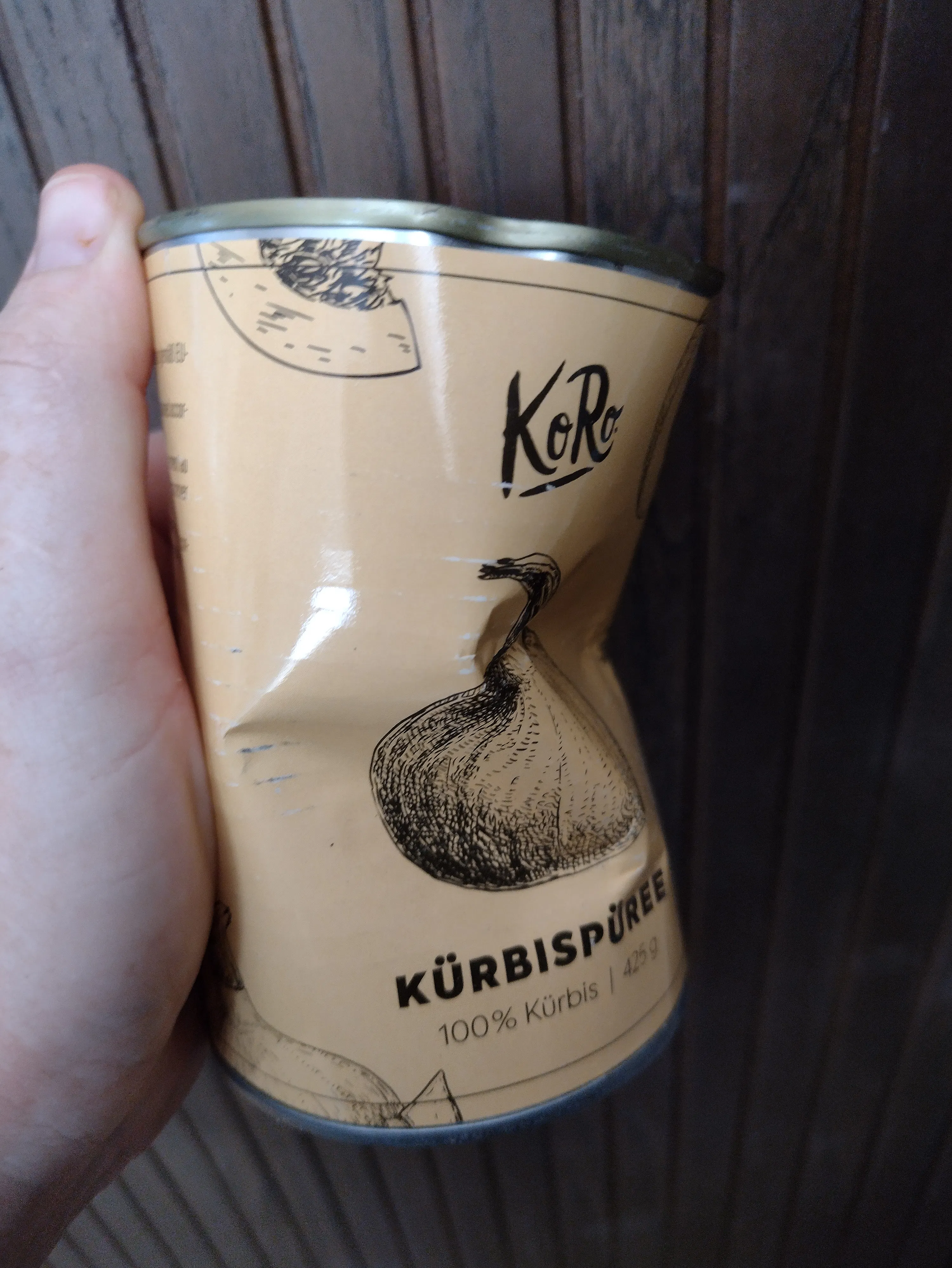 eine Person hält eine Dose kürbispüree in der Hand