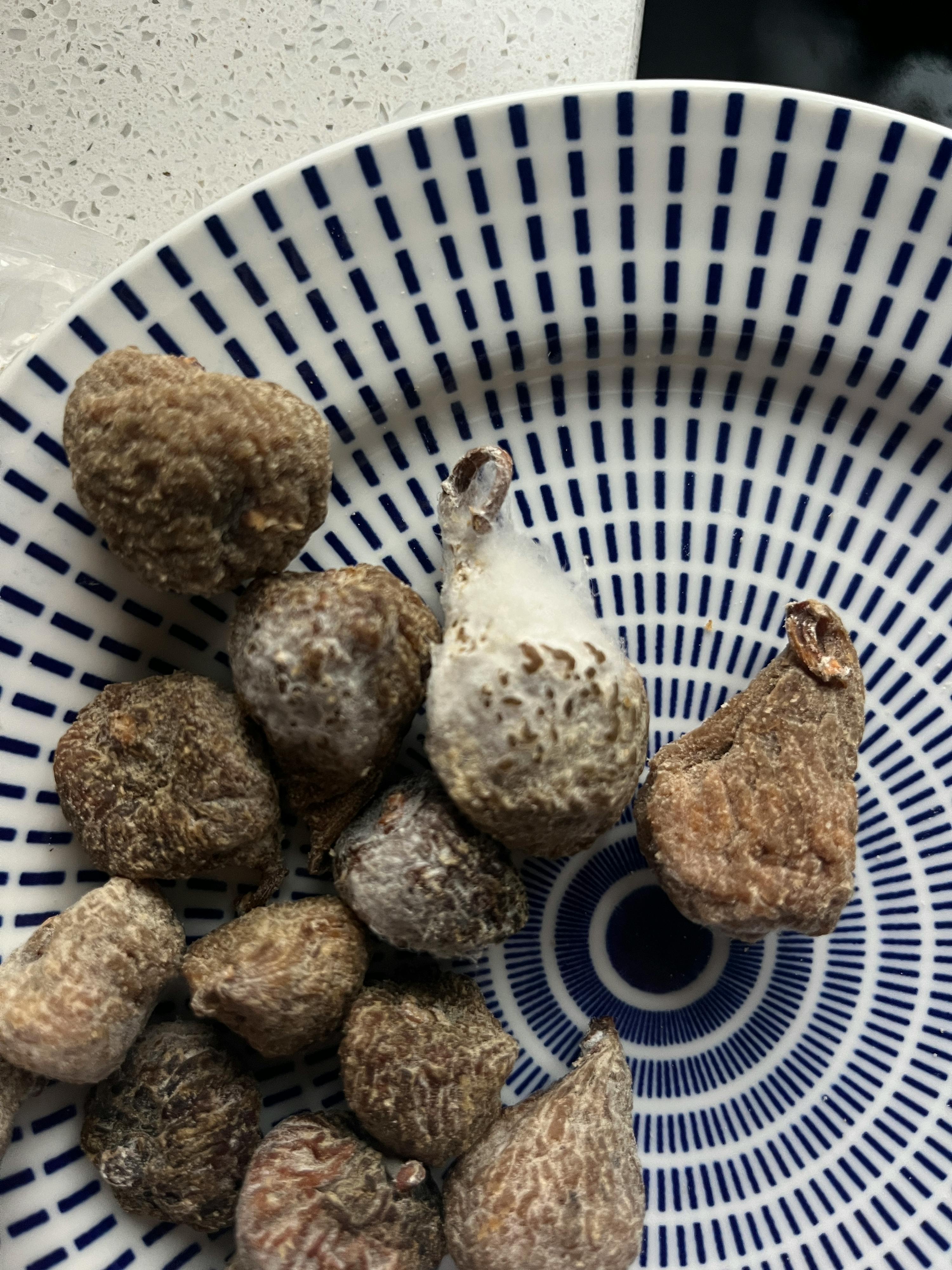 ein blau-weiß gestreifter Teller mit einem Haufen getrockneter Früchte darauf