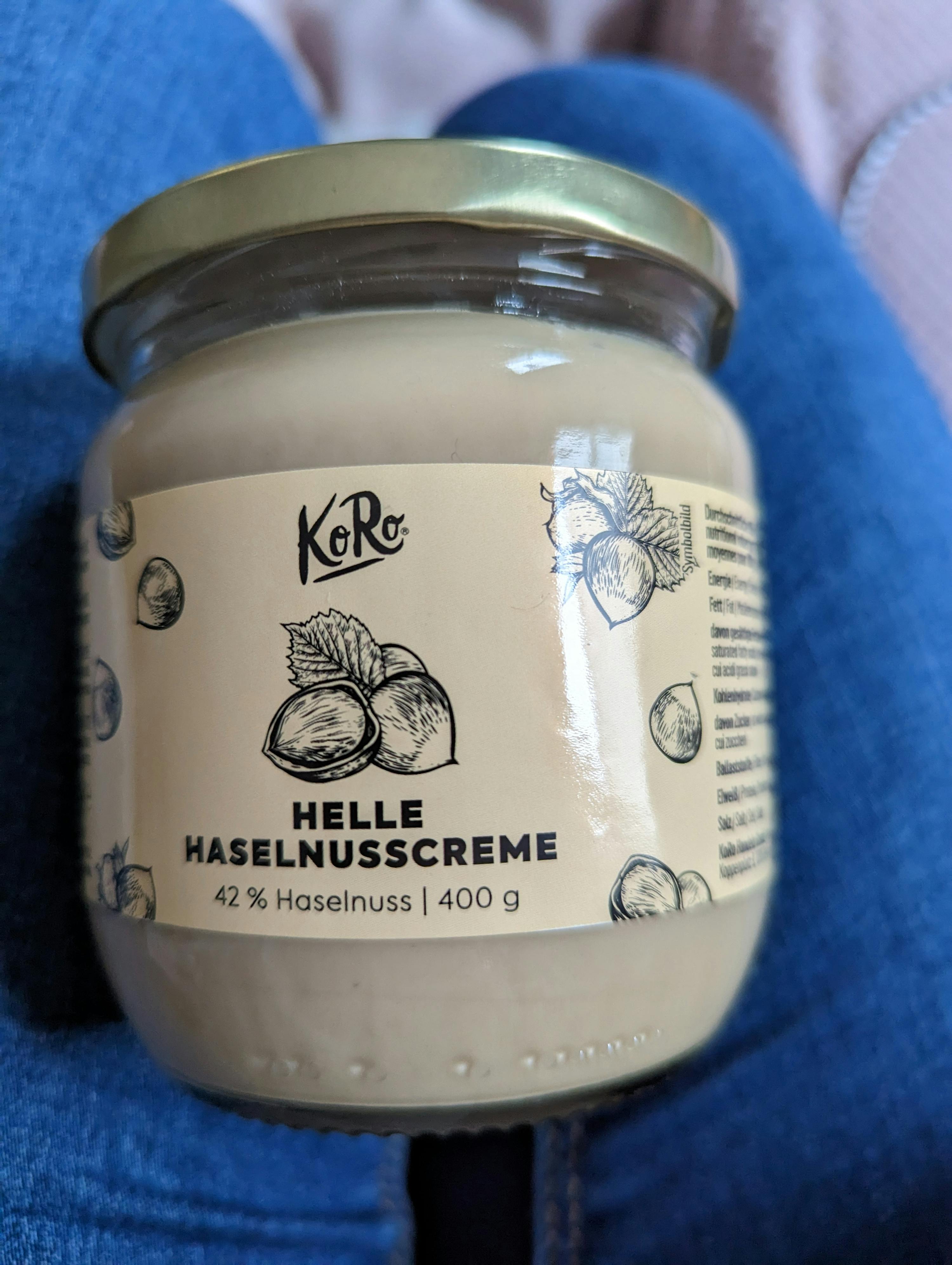 a jar of helle haselnusscreme sits on someone 's lap