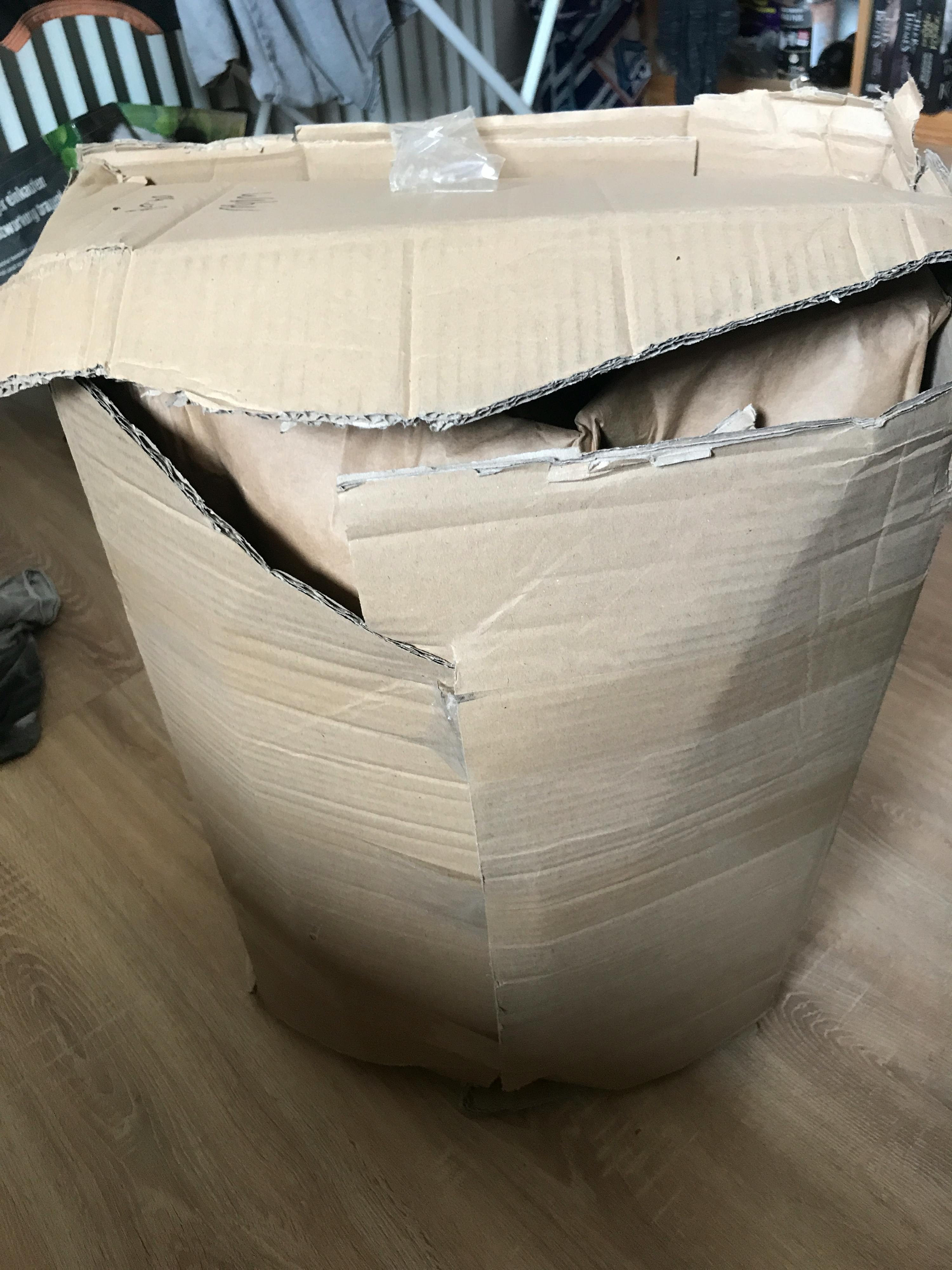 ein zerbrochener karton sitzt auf einem holzboden