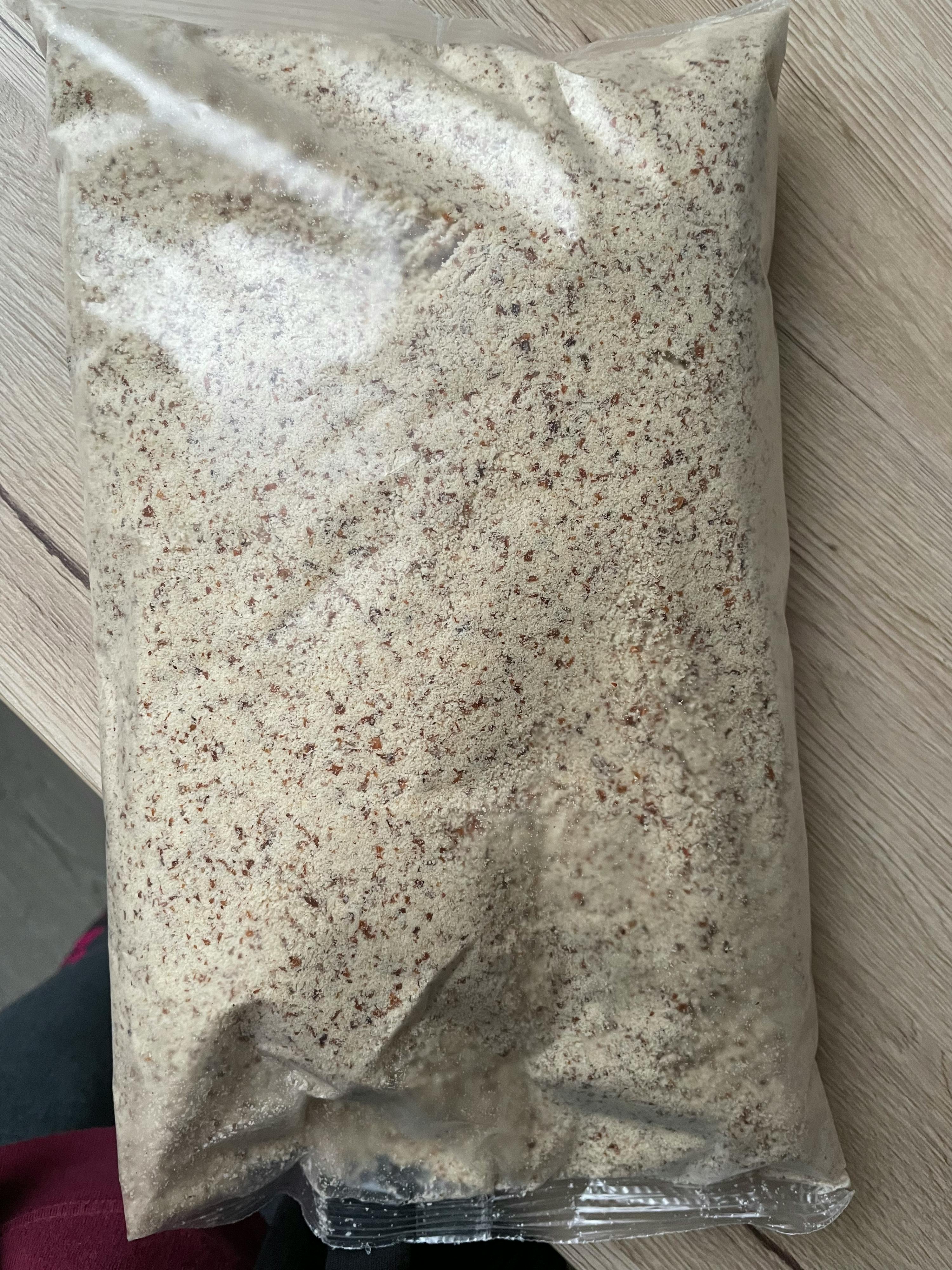 eine Plastiktüte mit braunem Pulver liegt auf einem Holztisch