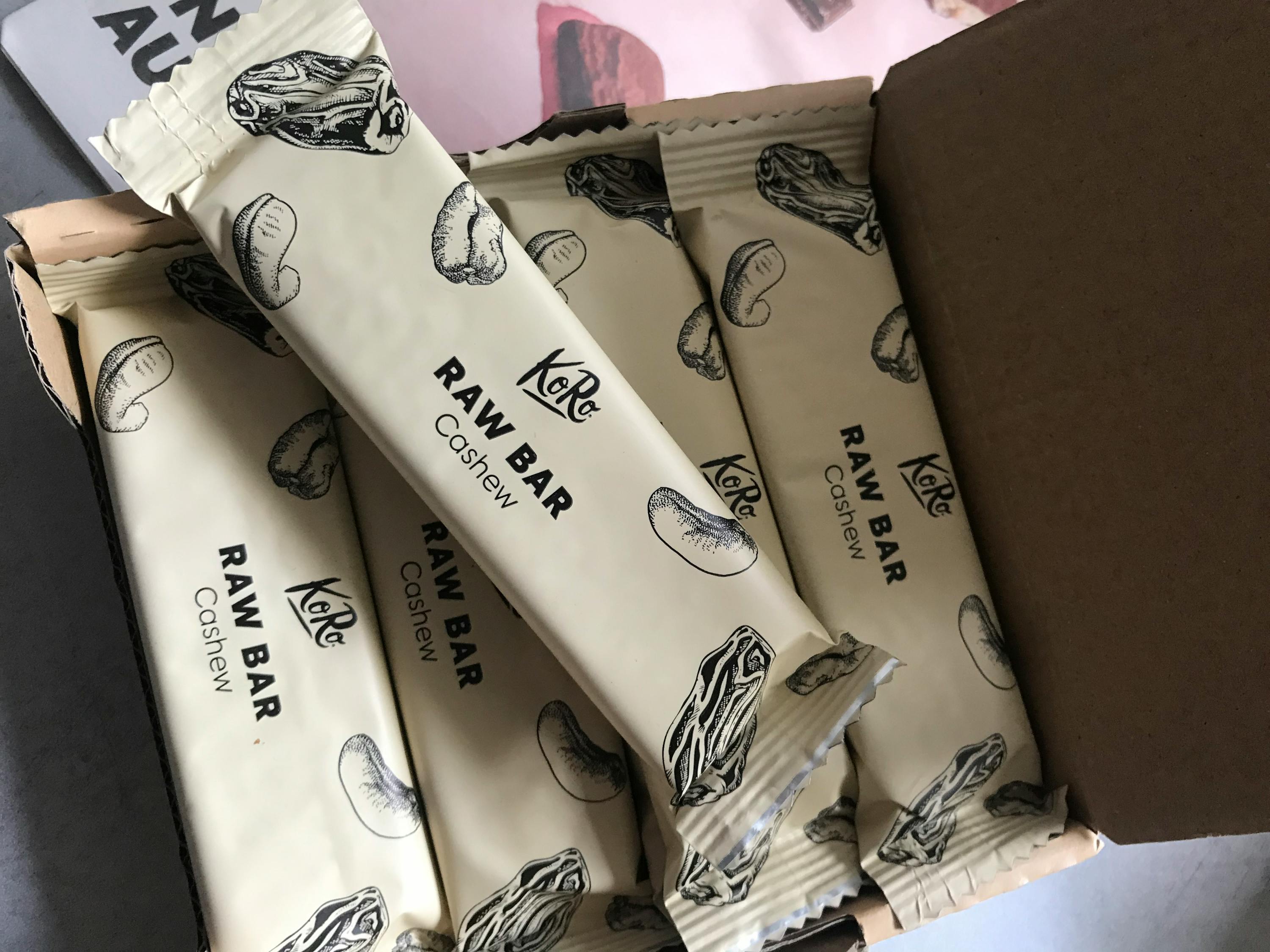 una scatola di barrette raw cashew è aperta su un tavolo