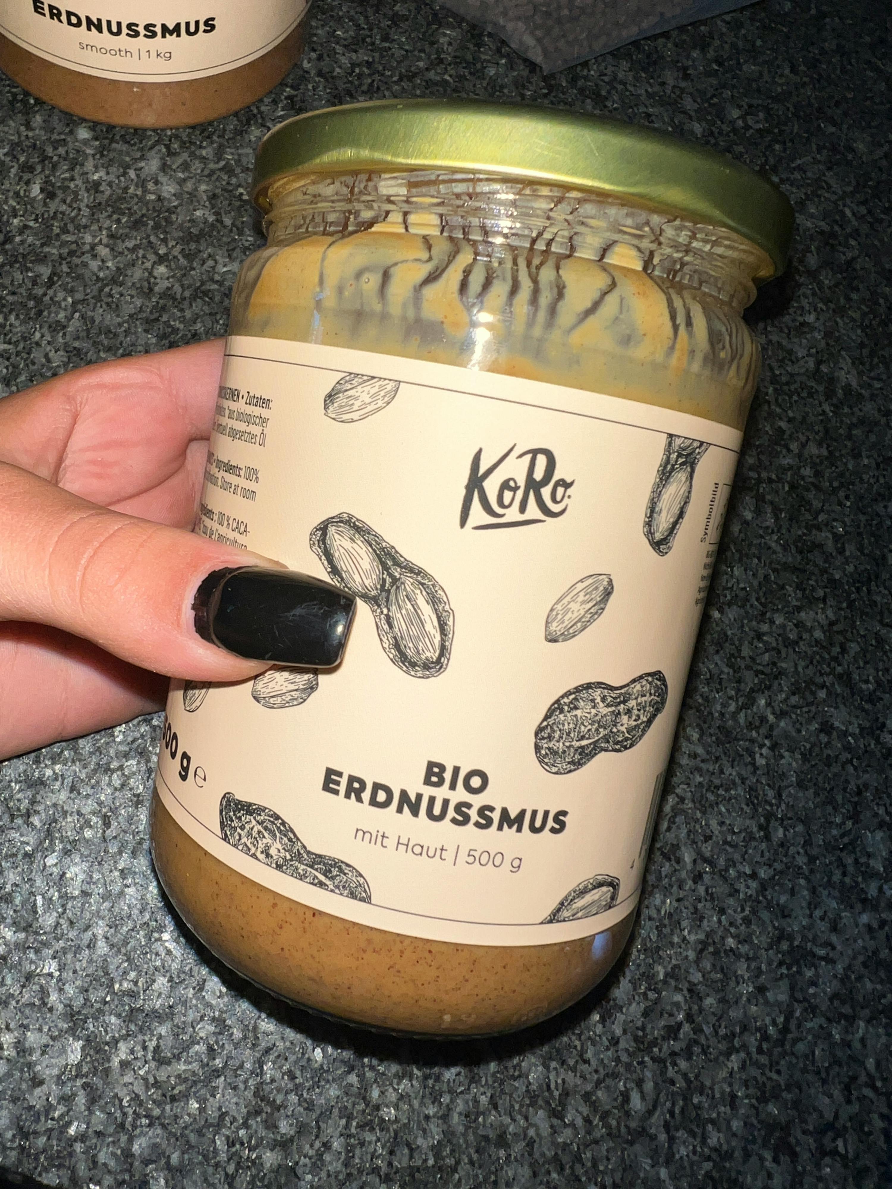 une personne tient un bocal de beurre d' arachide bio