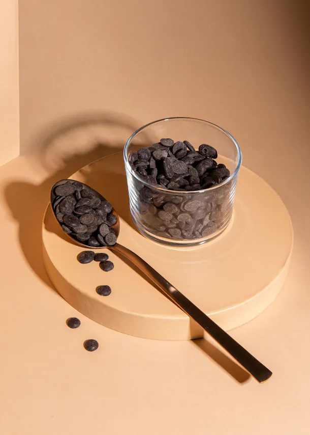 un bol en verre rempli de pépites de chocolat et une cuillère