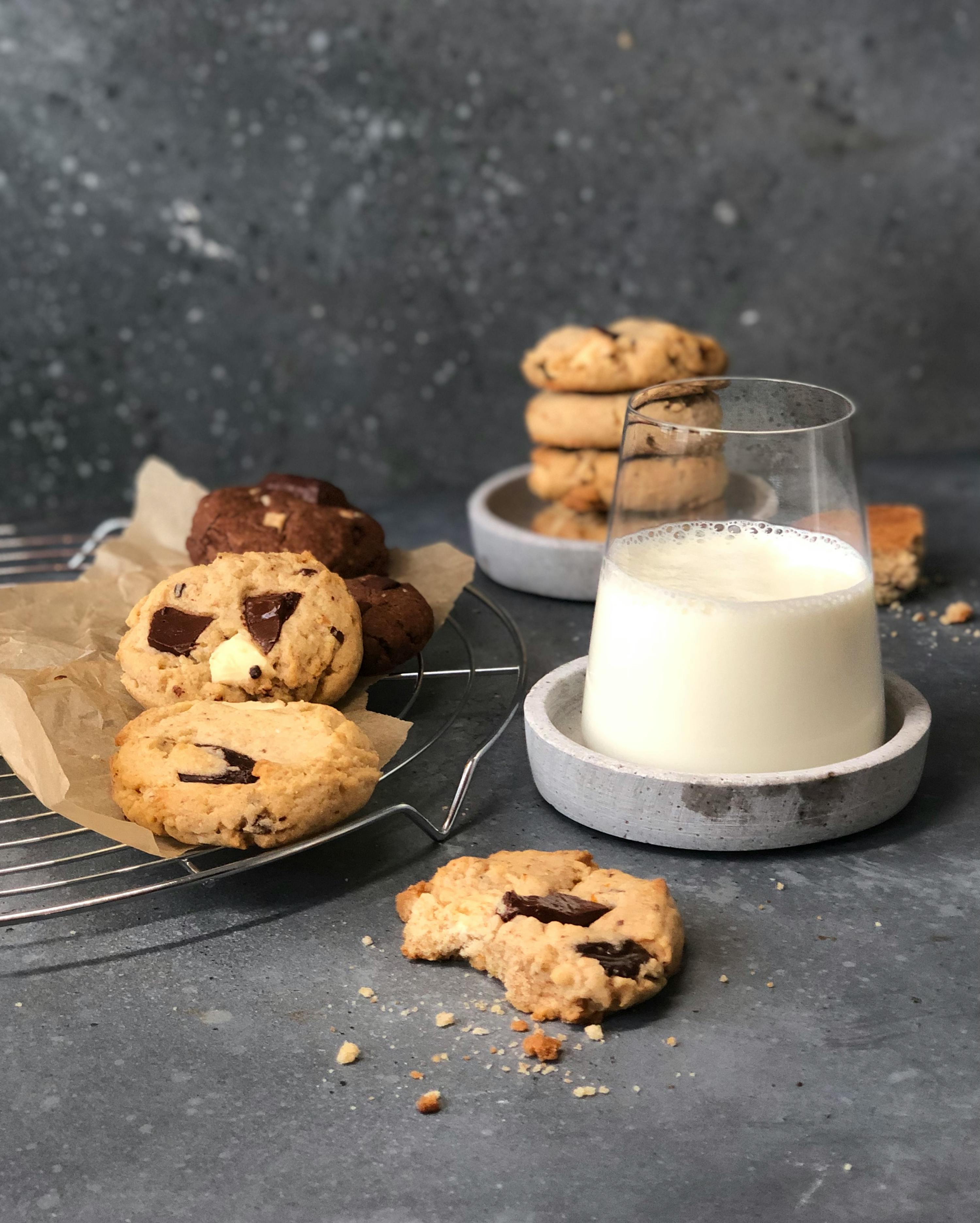 a glass of milk sits next to a stack of cookies