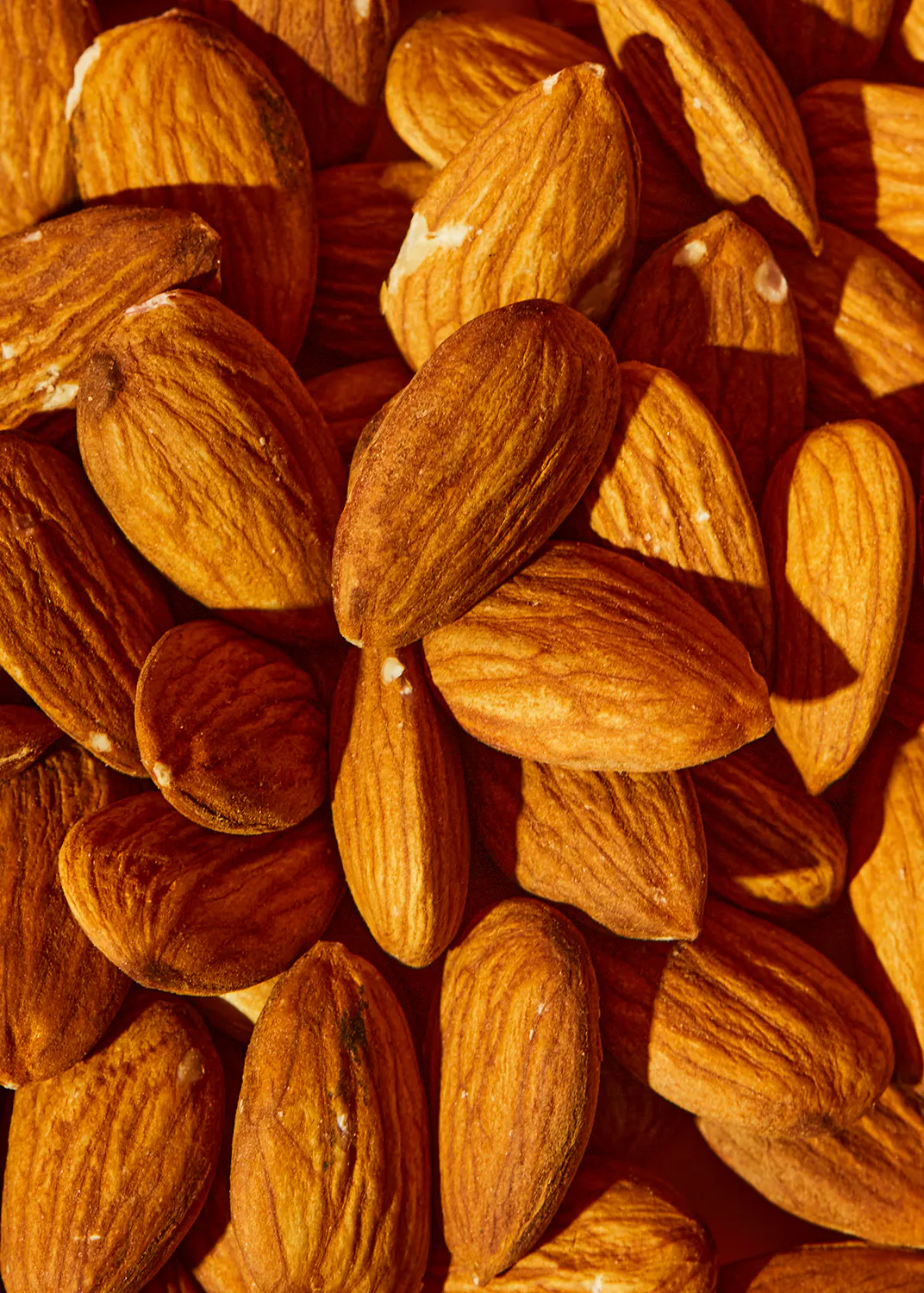 un gros plan d' un tas d' amandes avec des graines visibles