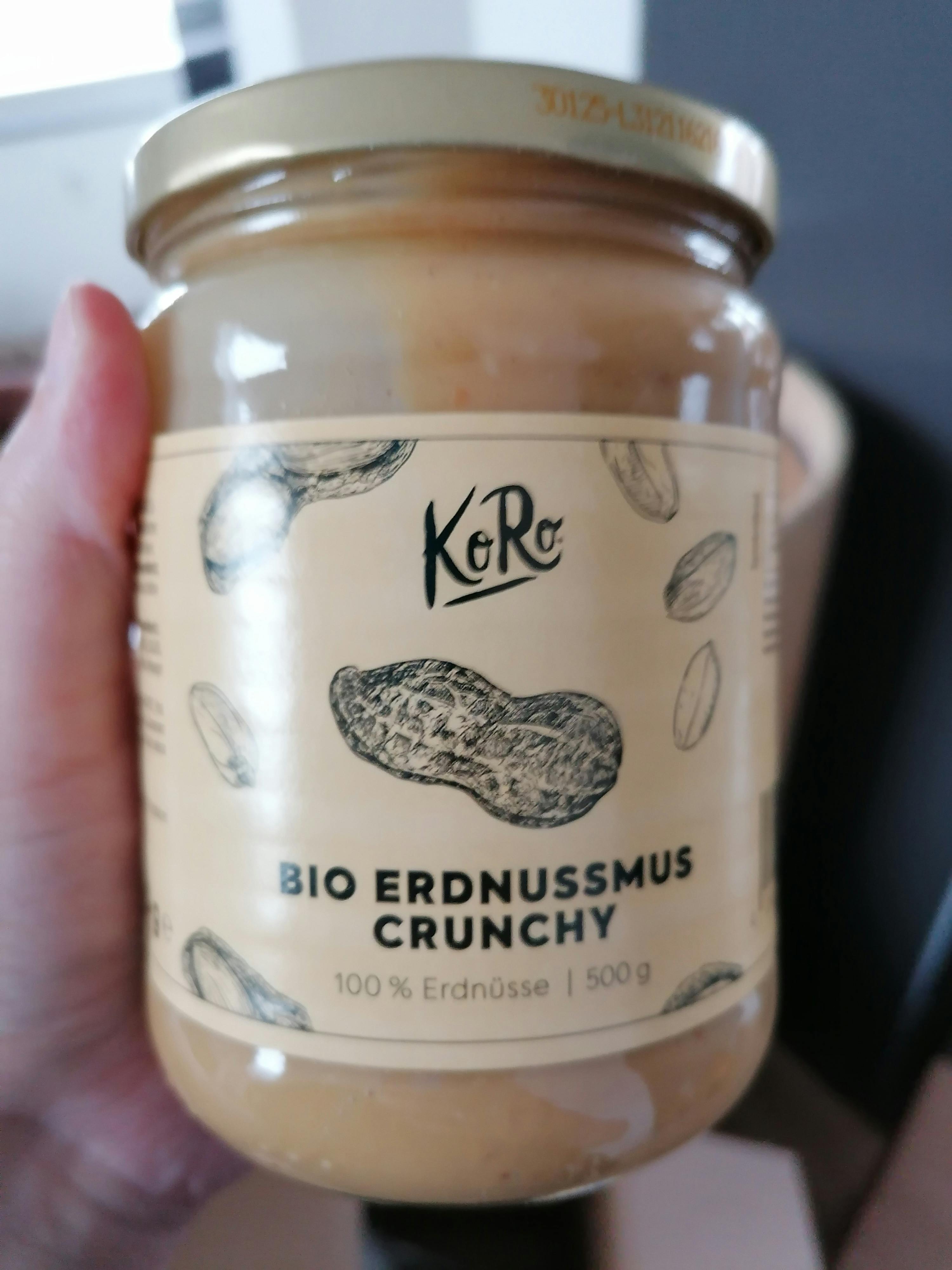 eine Person hält ein Glas bio Erdnussmus crunchy in der Hand