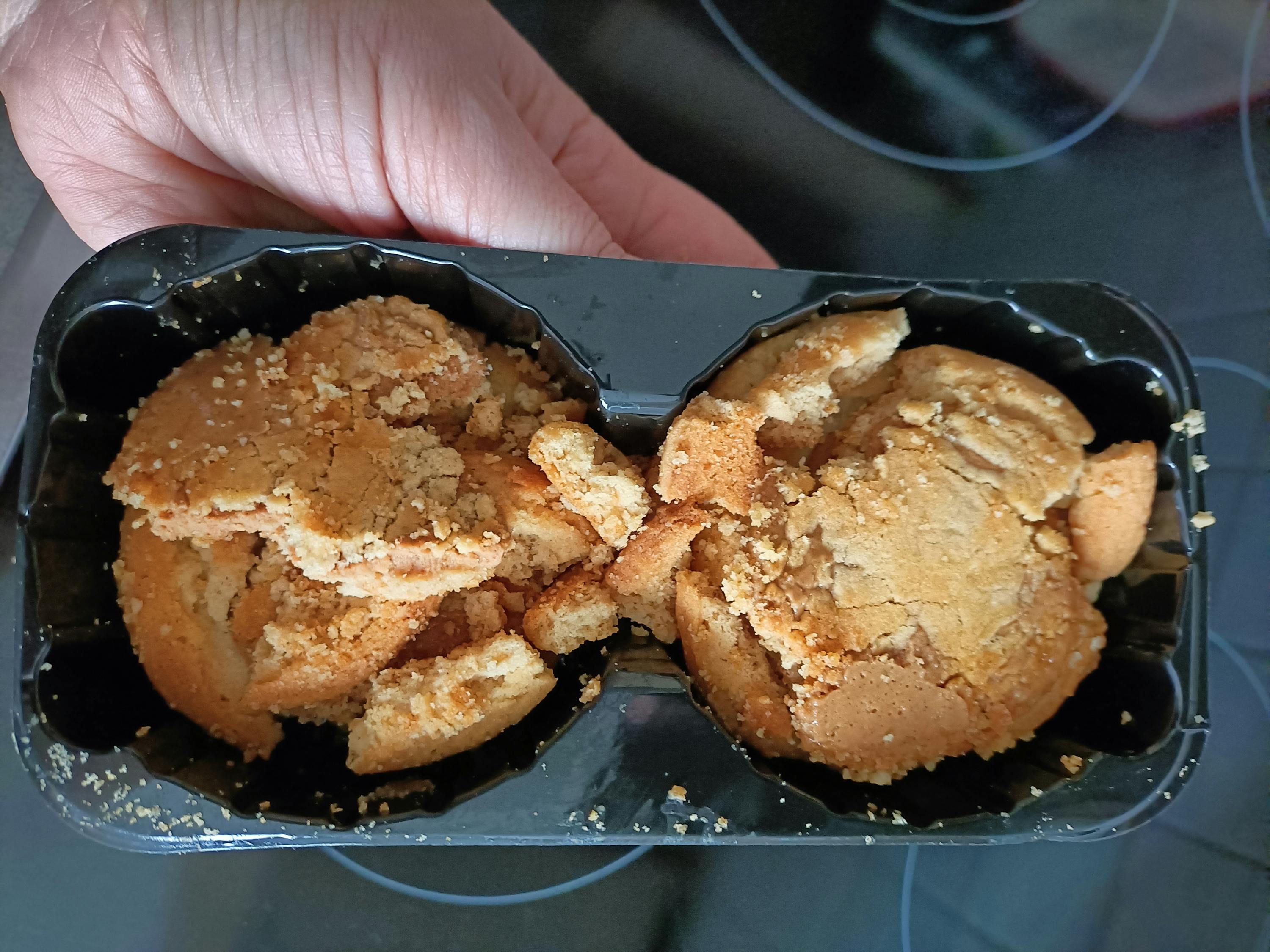 una persona tiene in mano una scatola di biscotti rotti