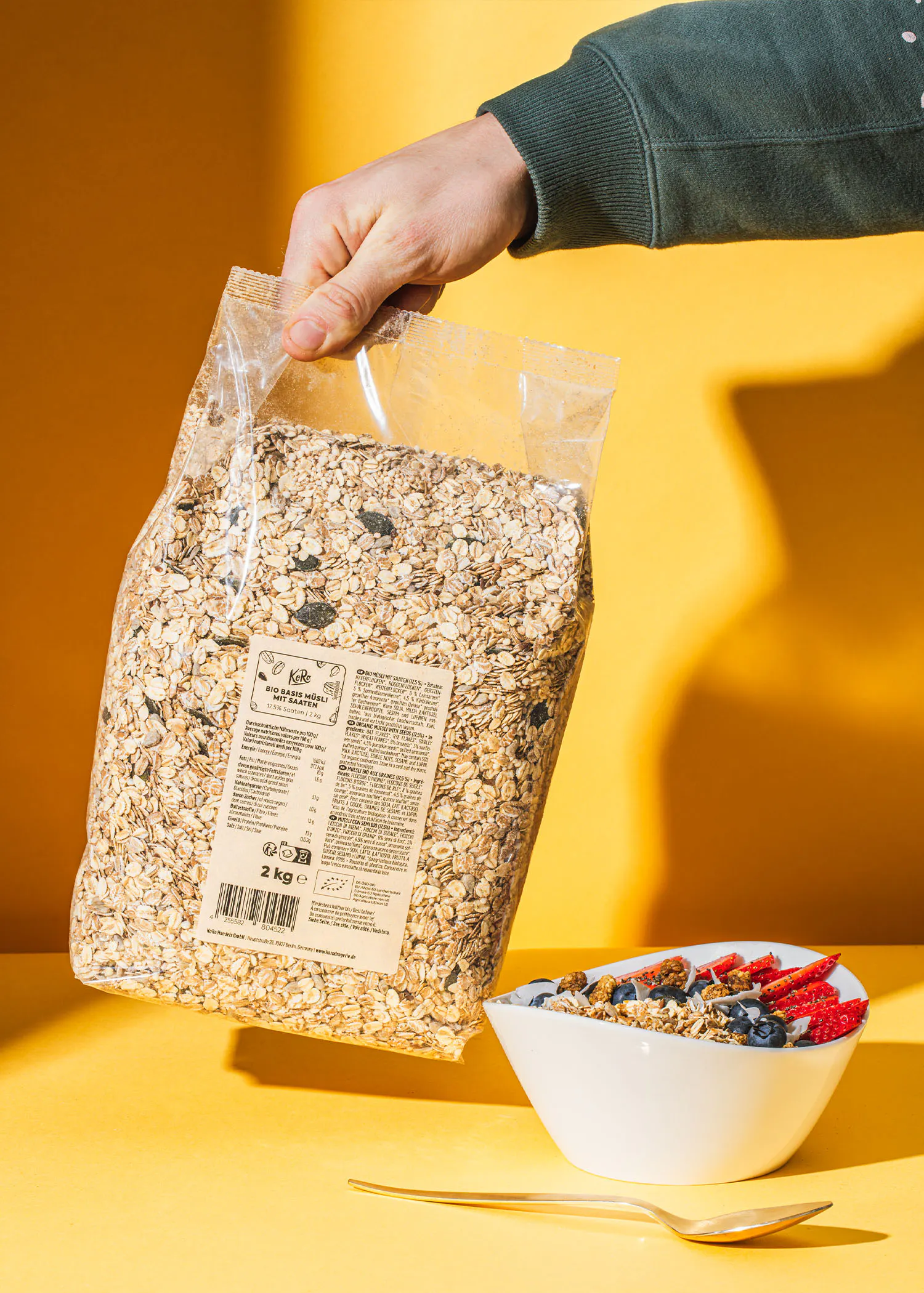 une personne tient un sac d' avoine à côté d' un bol de céréales