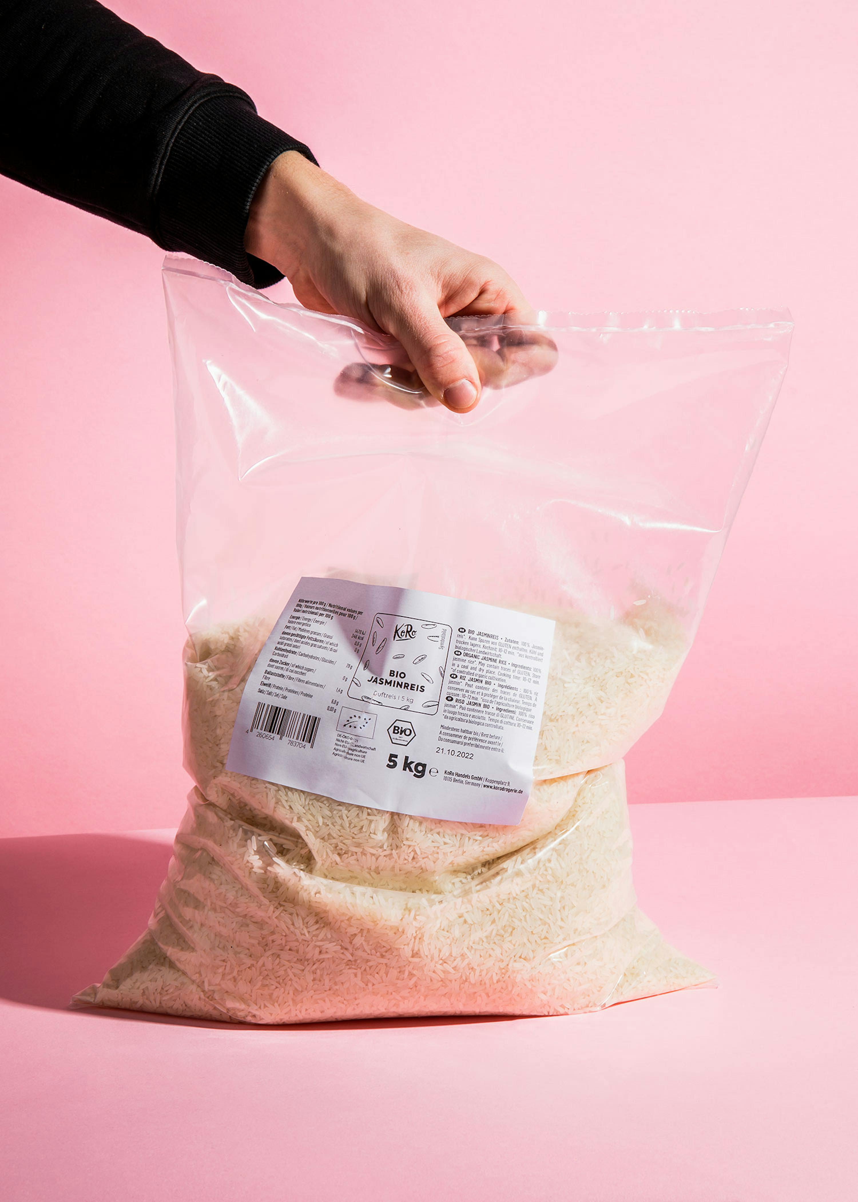 eine Person hält einen Plastikbeutel mit Reis in der Hand