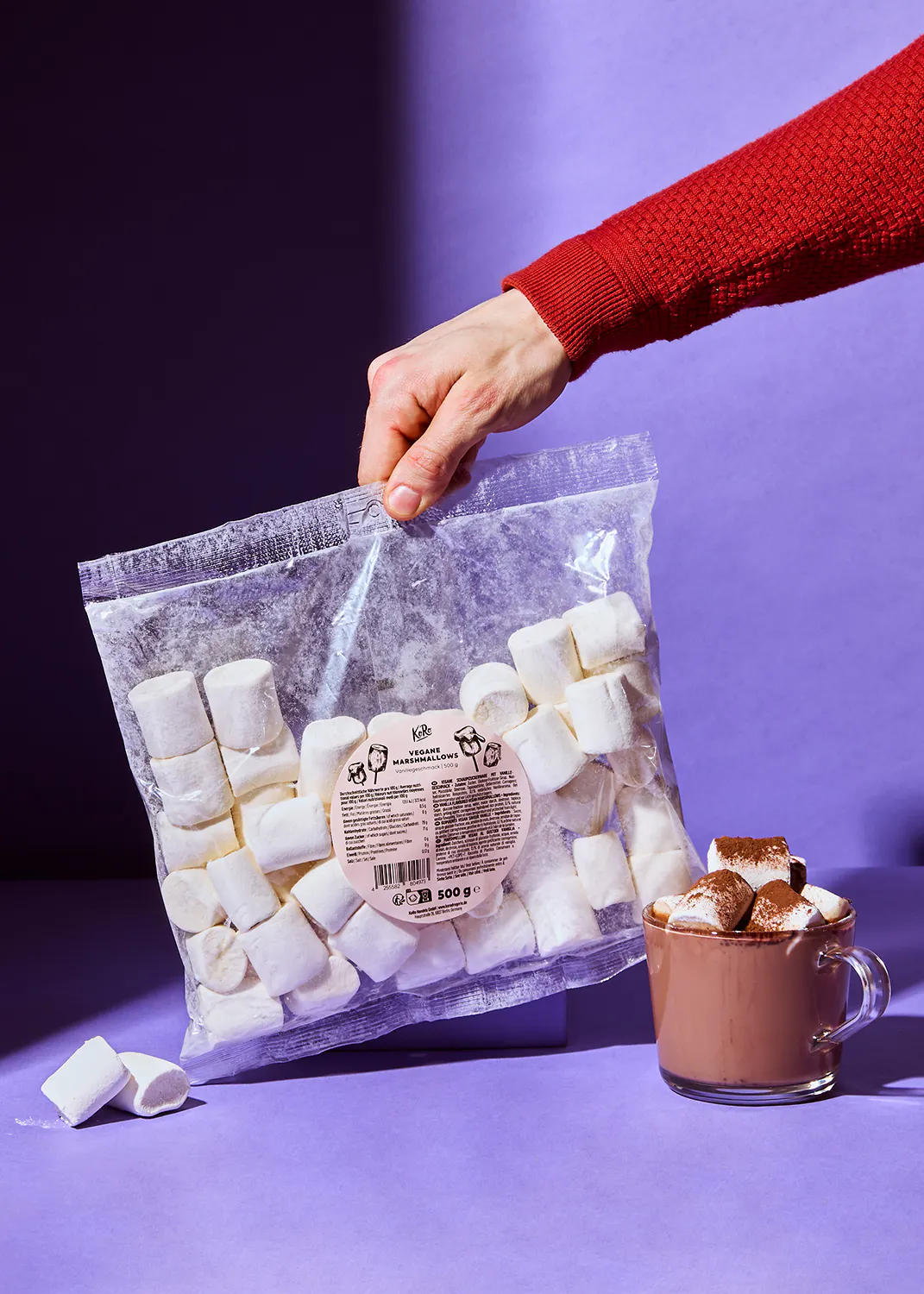 Eine Person hält eine Tüte Marshmallows in der Hand