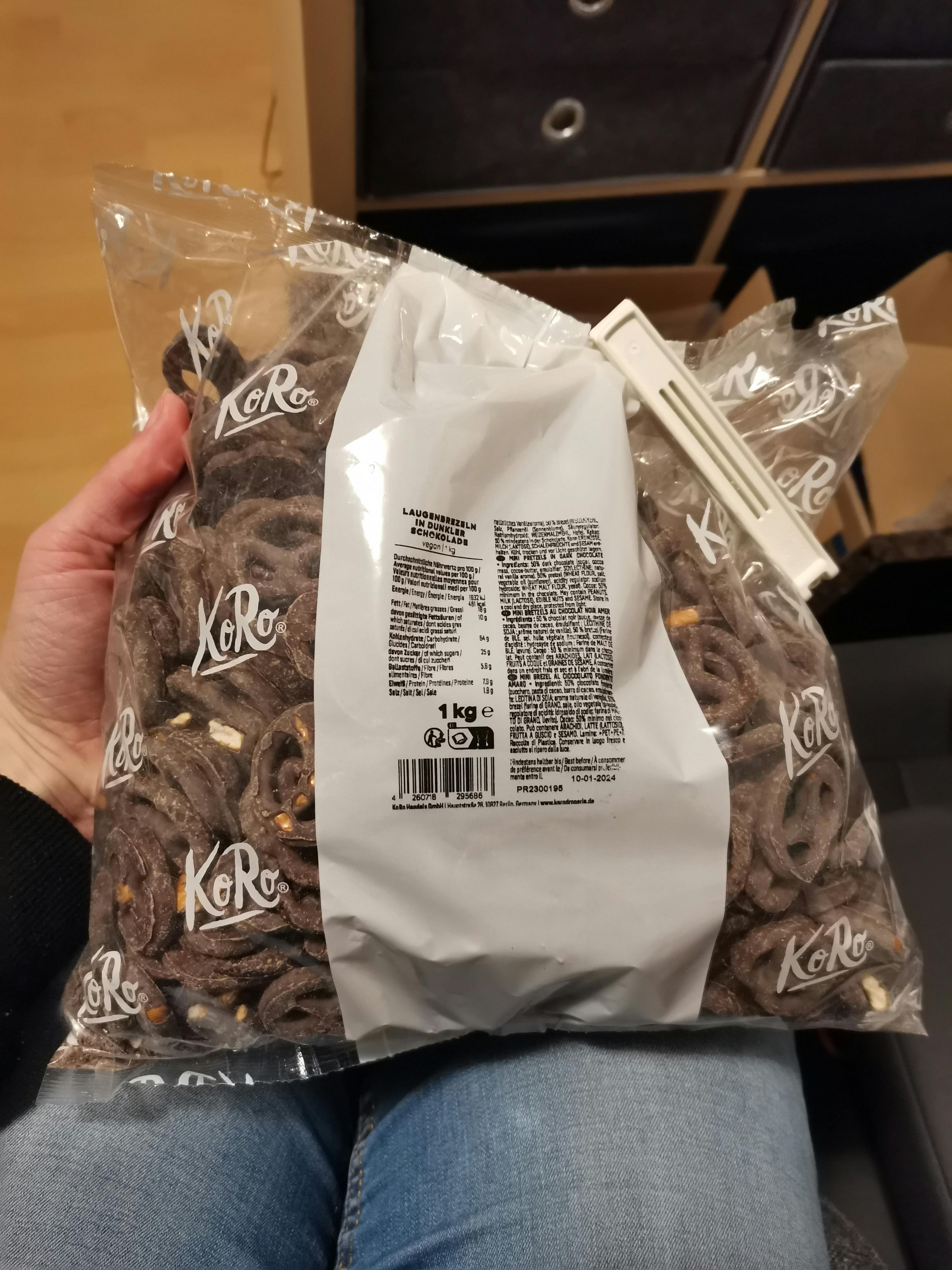 eine Person hält einen Plastikbeutel mit Schokoladenkringeln