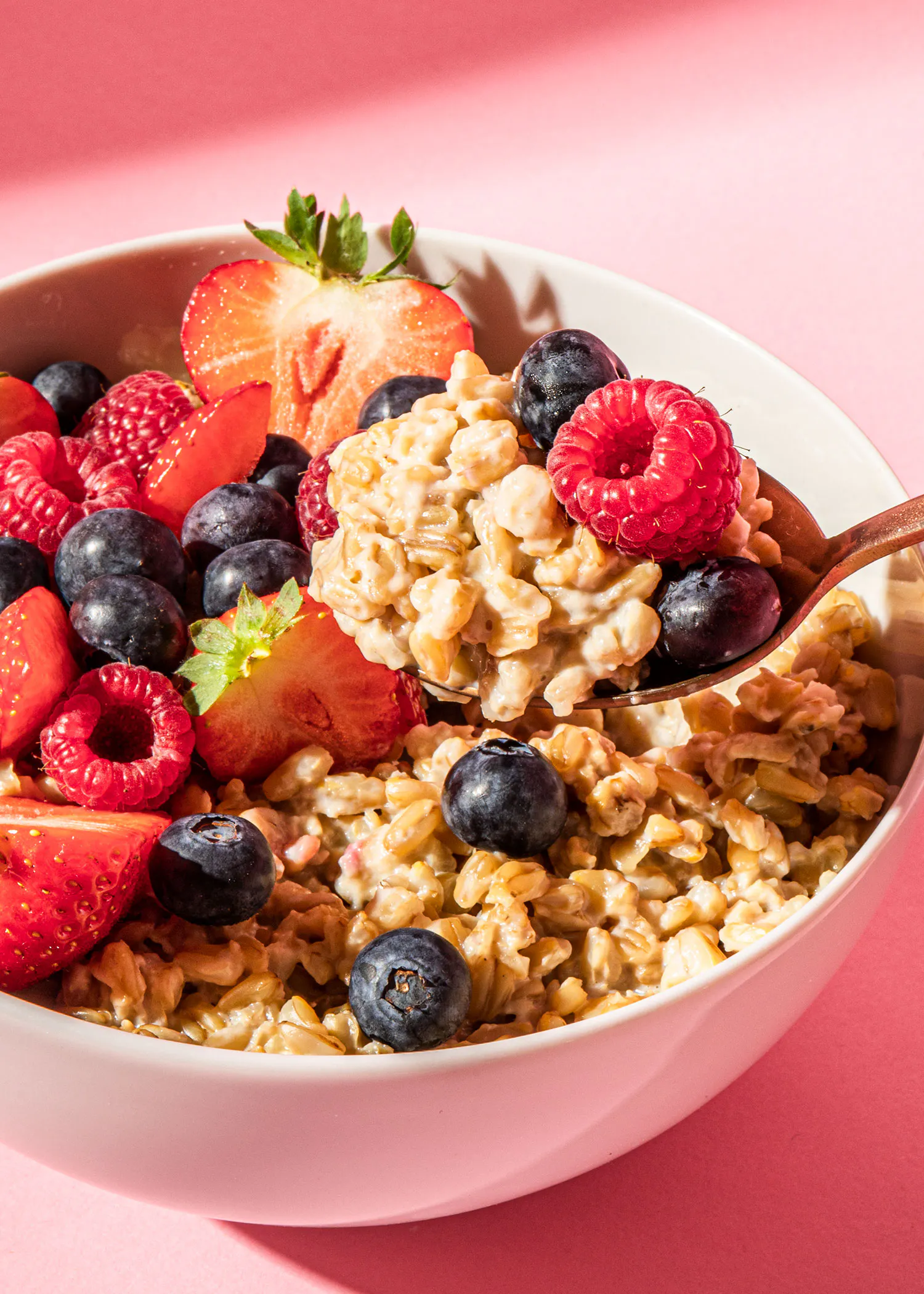 a bowl of oatmeal with strawberries blueberries and raspberries