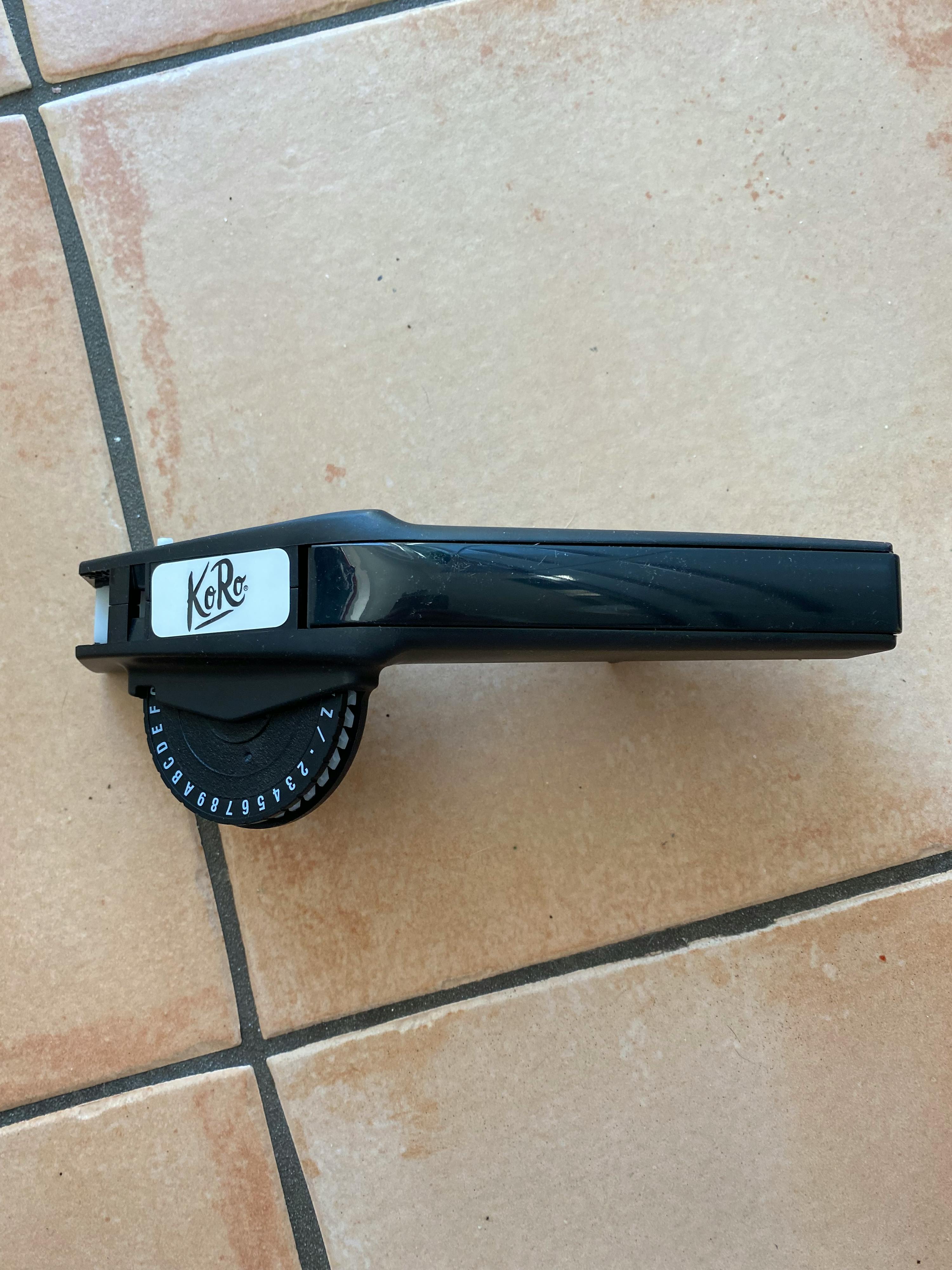 a k & r tape dispenser is sitting on a tiled floor