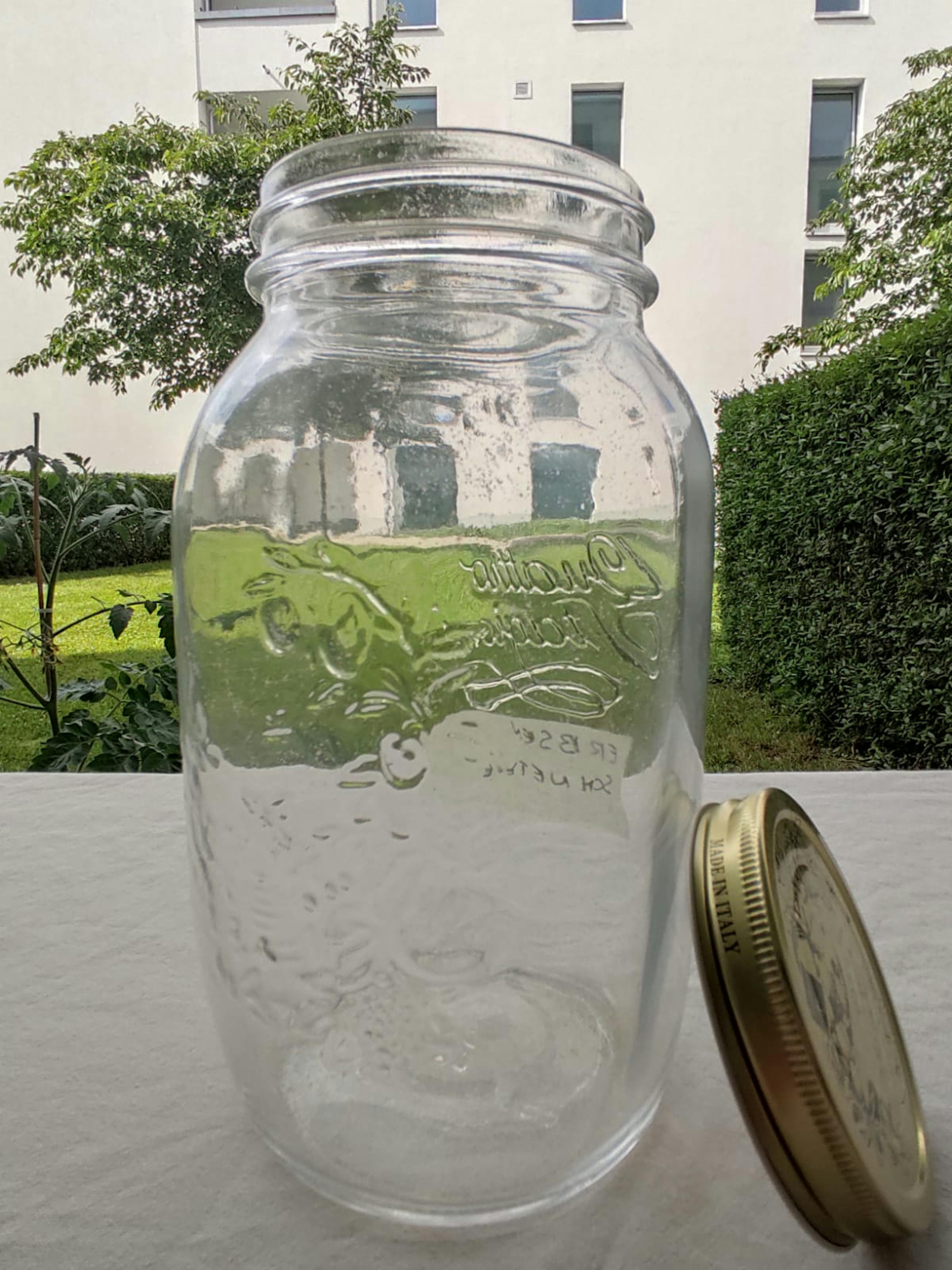 ein Glasgefäß mit einem goldenen Deckel steht auf einem Tisch