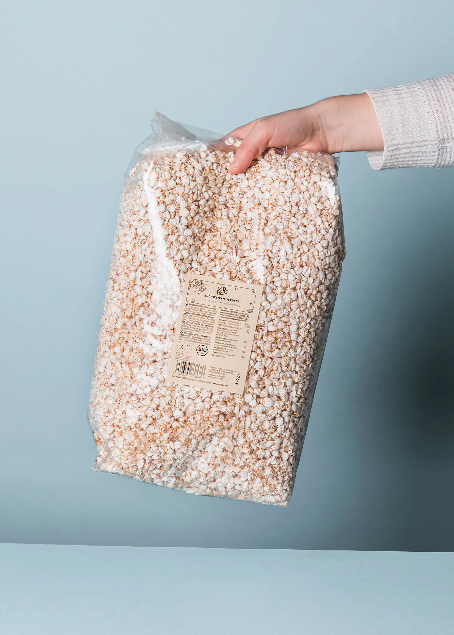 une personne tient un sac de pop-corn avec l' étiquette kolb