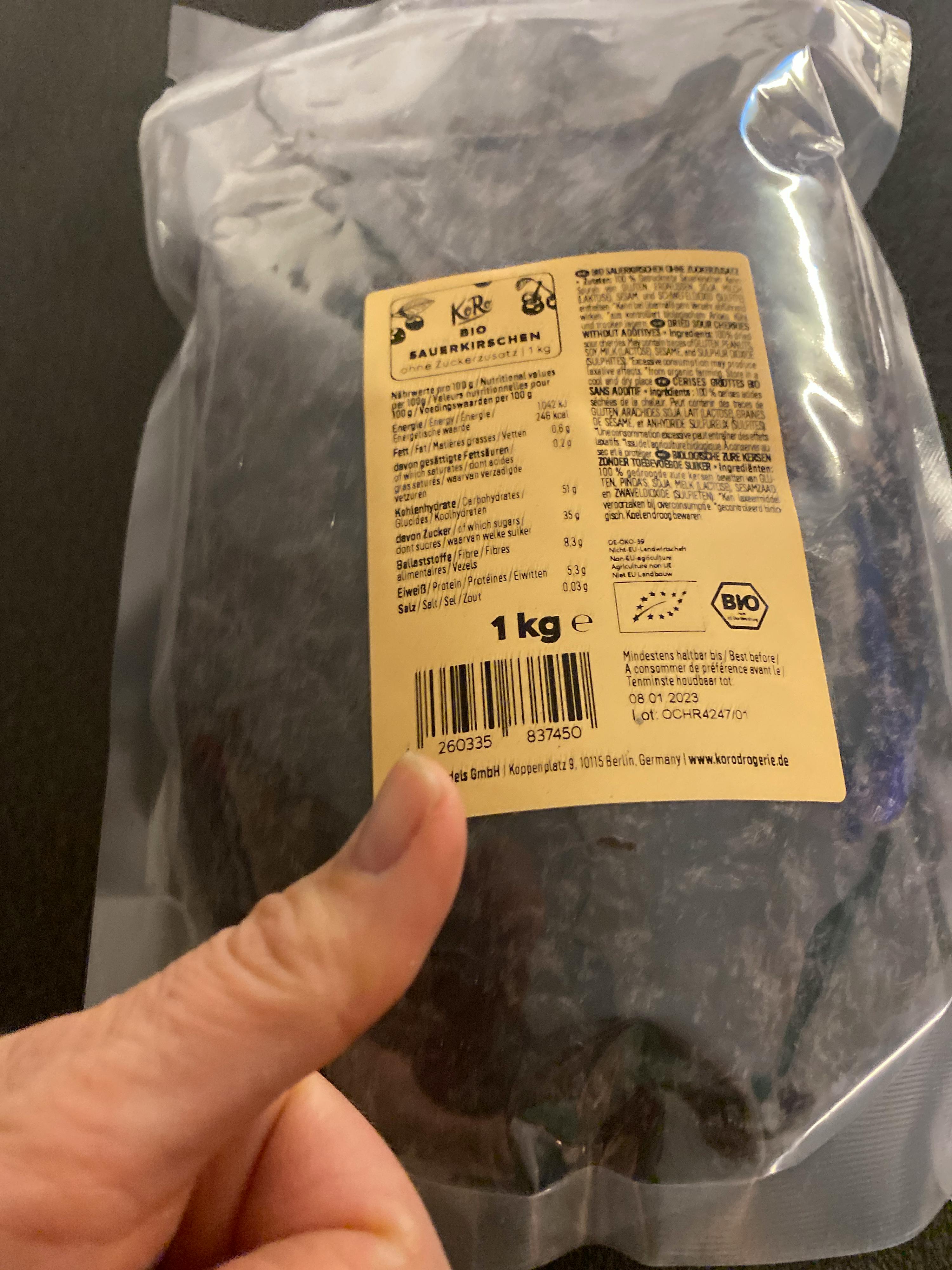 une personne pointe vers l' étiquette d' un sac de 1 kg de nourriture