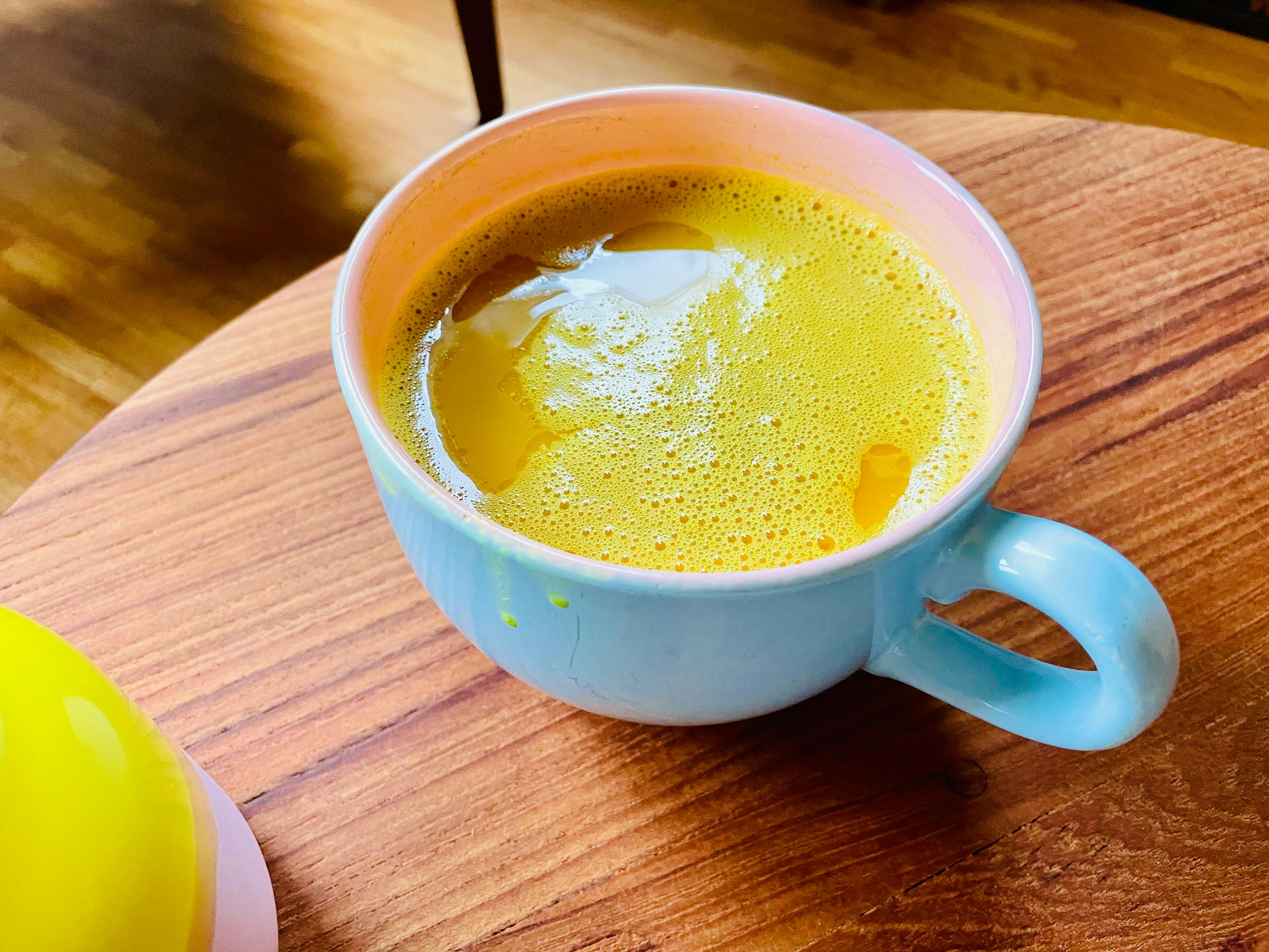 eine blaue und rosa Tasse mit einer gelben Flüssigkeit darin