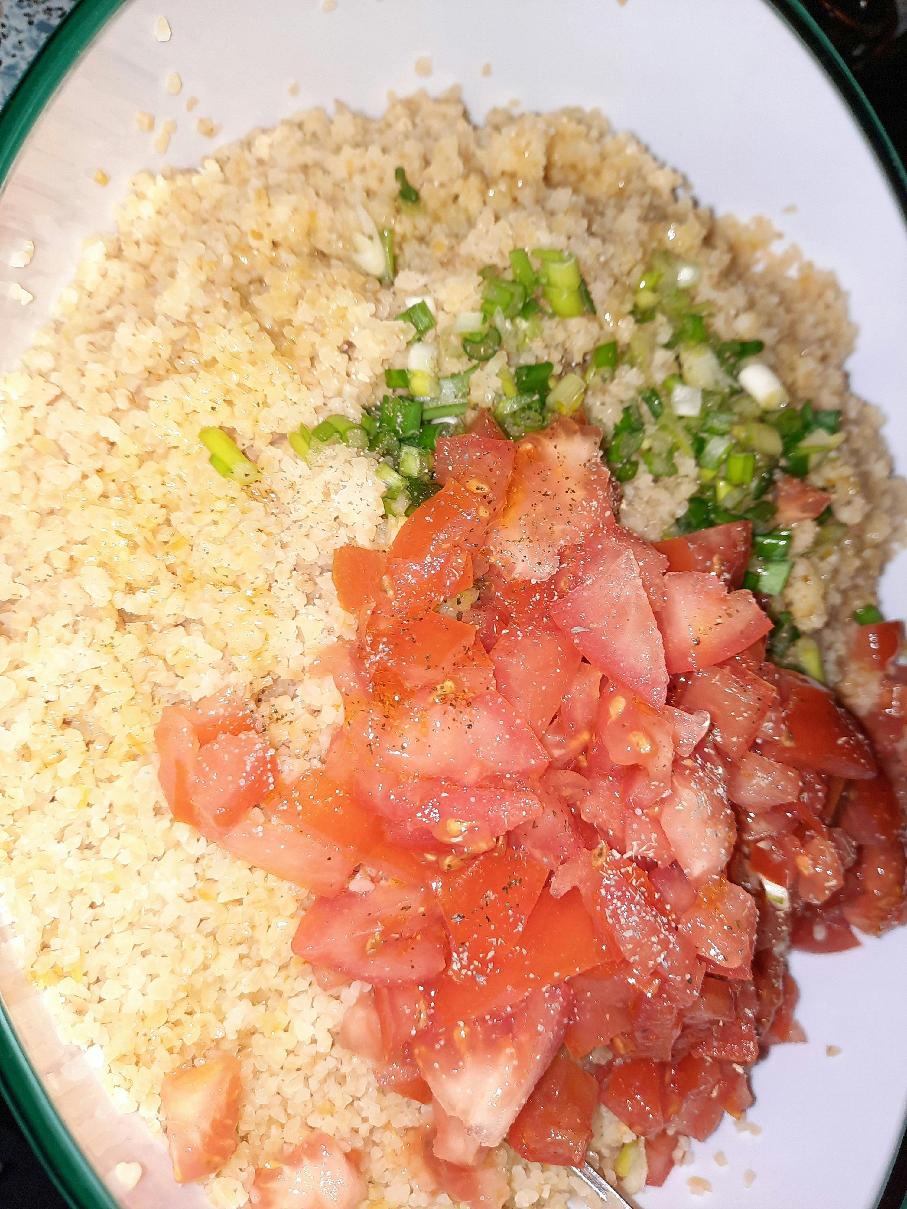 eine schüssel mit couscous , tomaten und zwiebeln