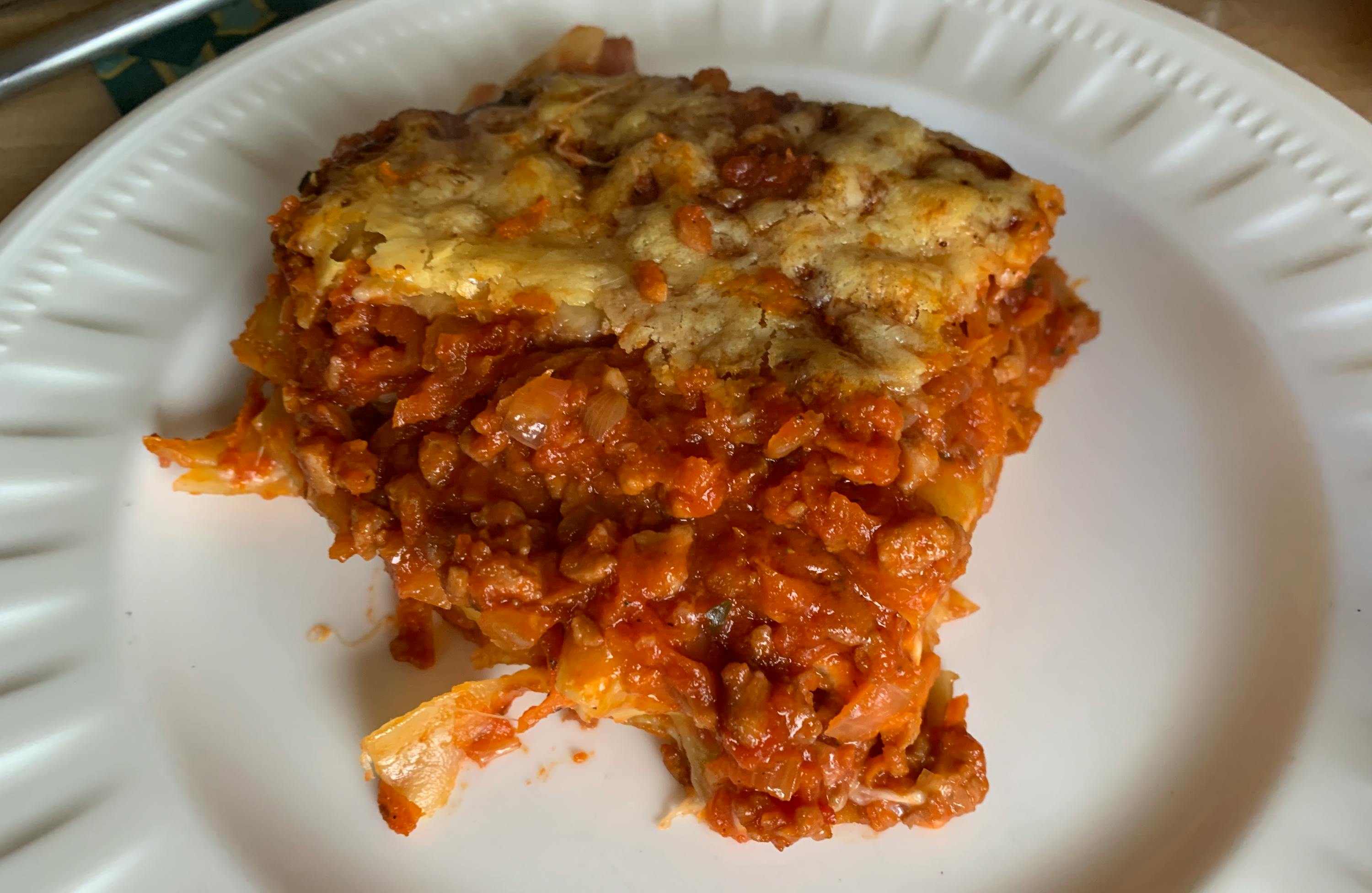 a white plate topped with a slice of lasagna