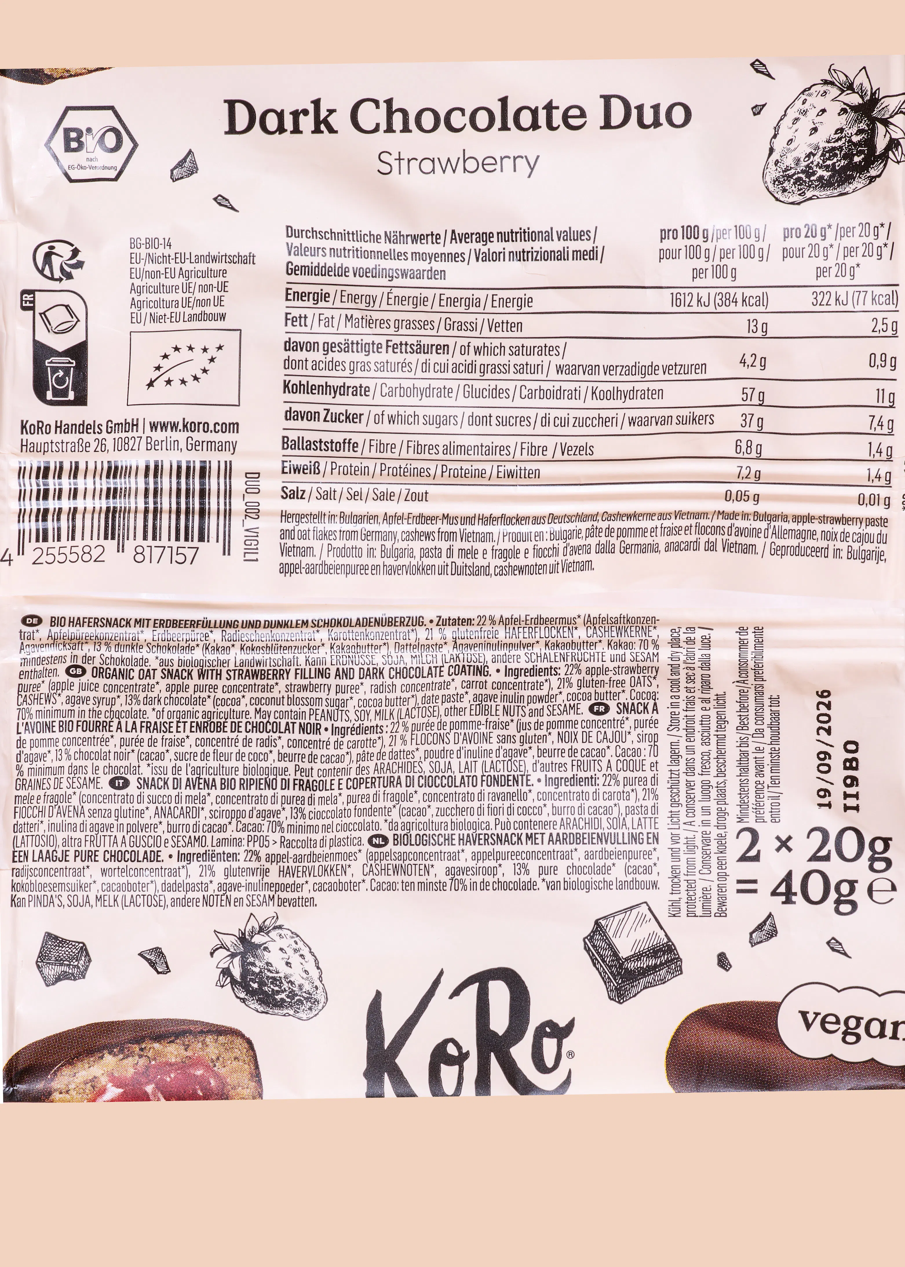rückseite einer verpackung für dunkle schokolade mit erdbeerfüllung der marke koro, mit nährwertangaben, zutatenliste und dem vegan-logo.