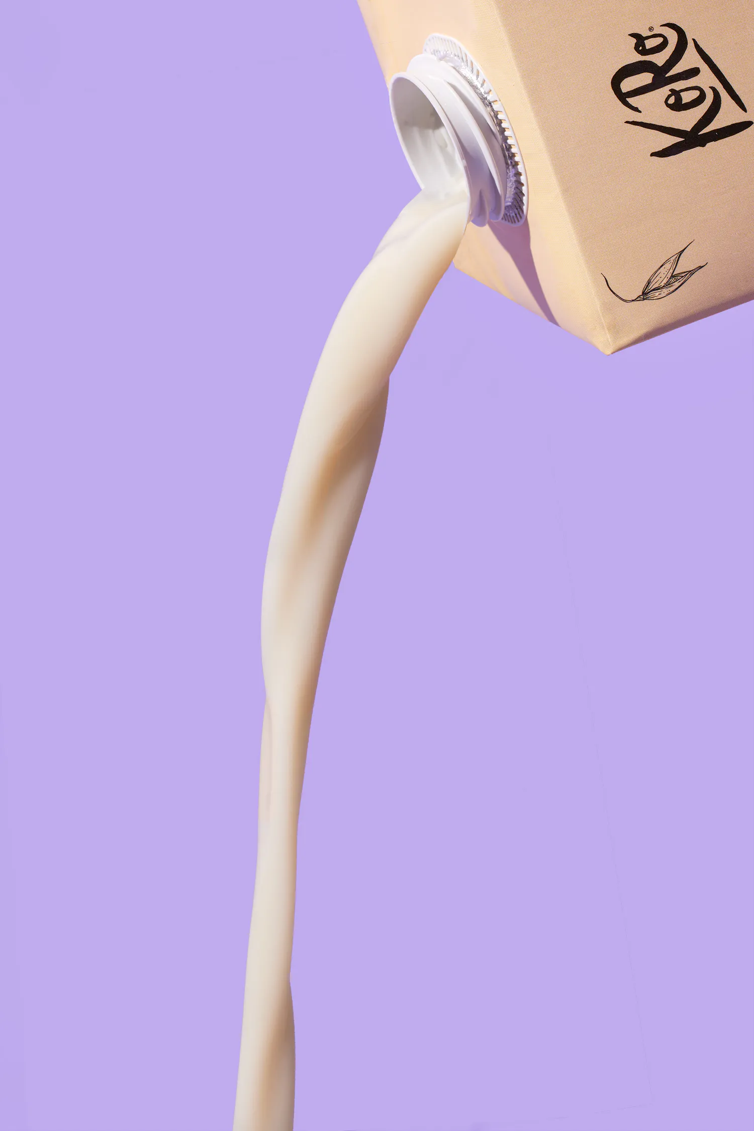 a carton of soy milk is being poured into a cup