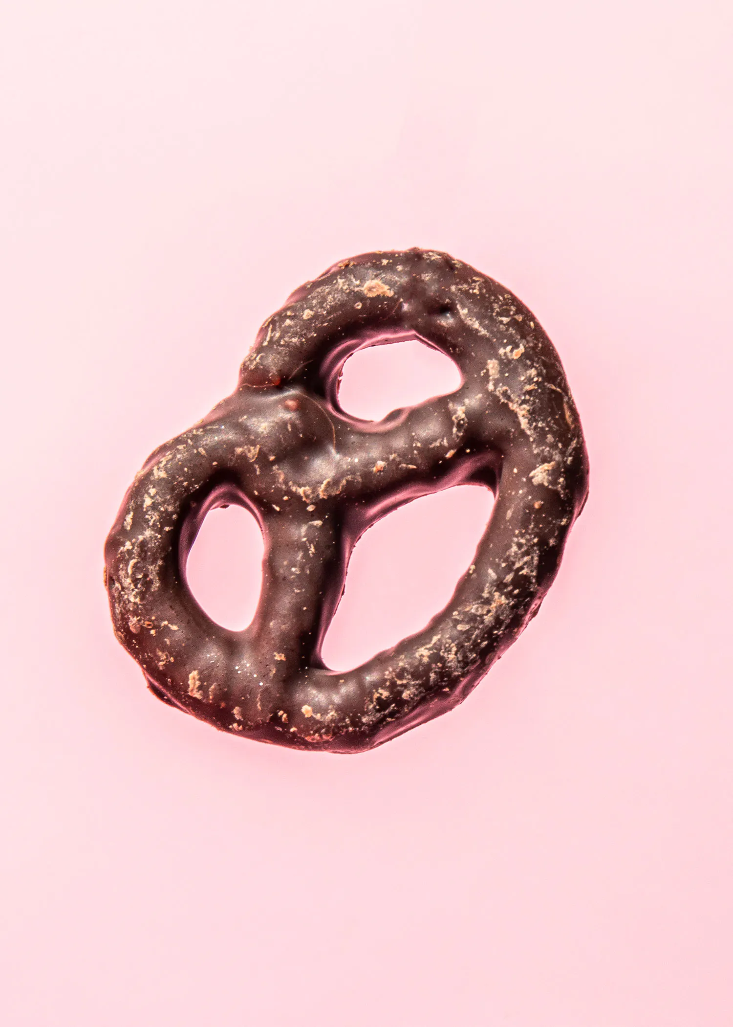 un bretzel au chocolat sur fond rose