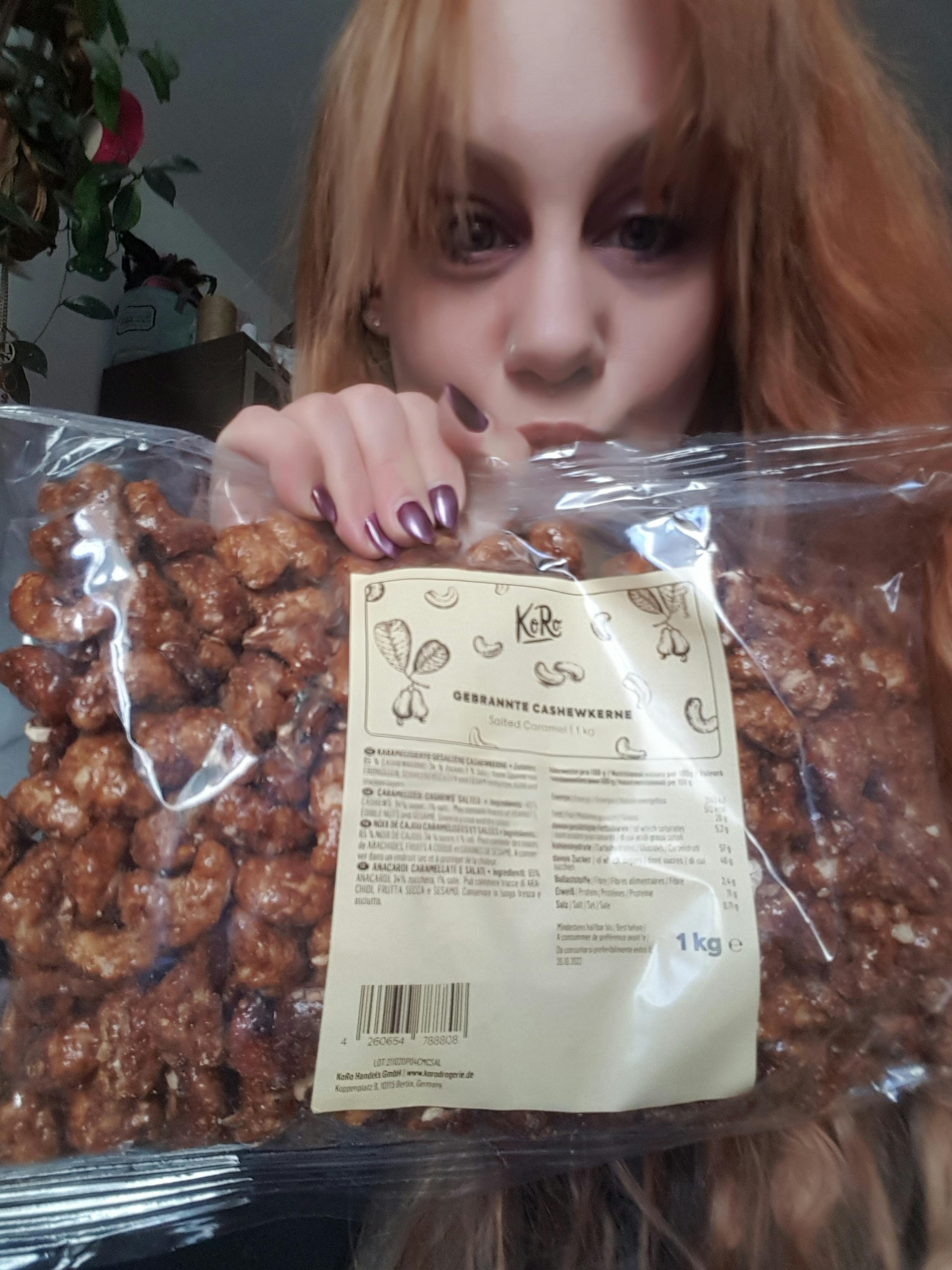 a woman holding a bag of caramelized almonds