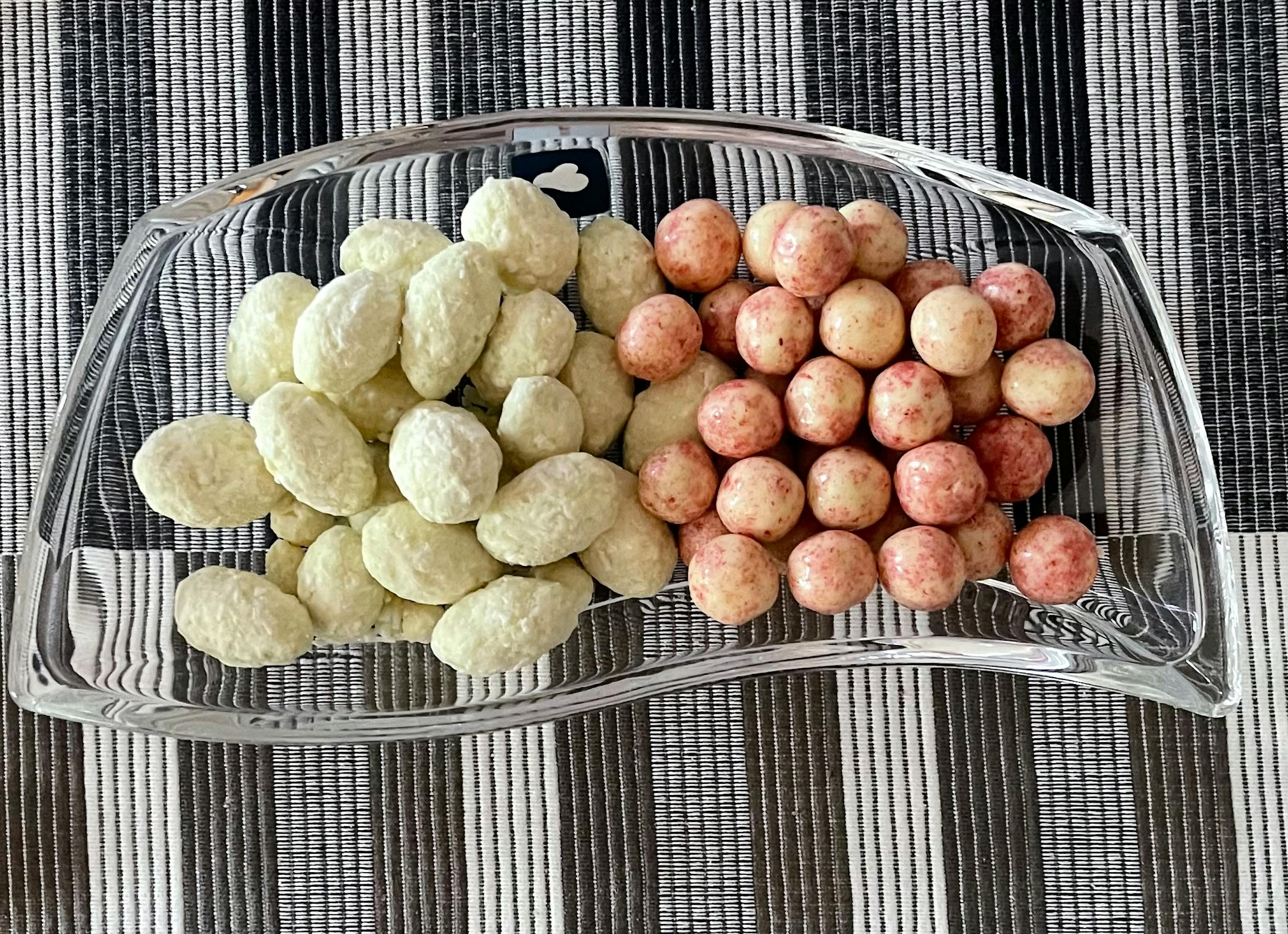 ein Glasteller mit zwei verschiedenen Arten von Erdnüssen darauf