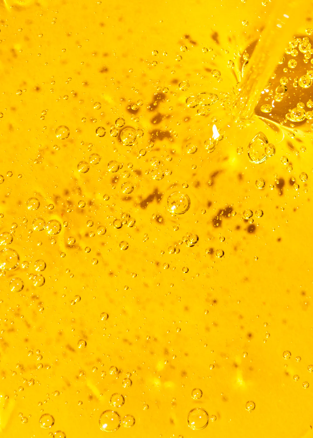 a close up of a yellow liquid with bubbles