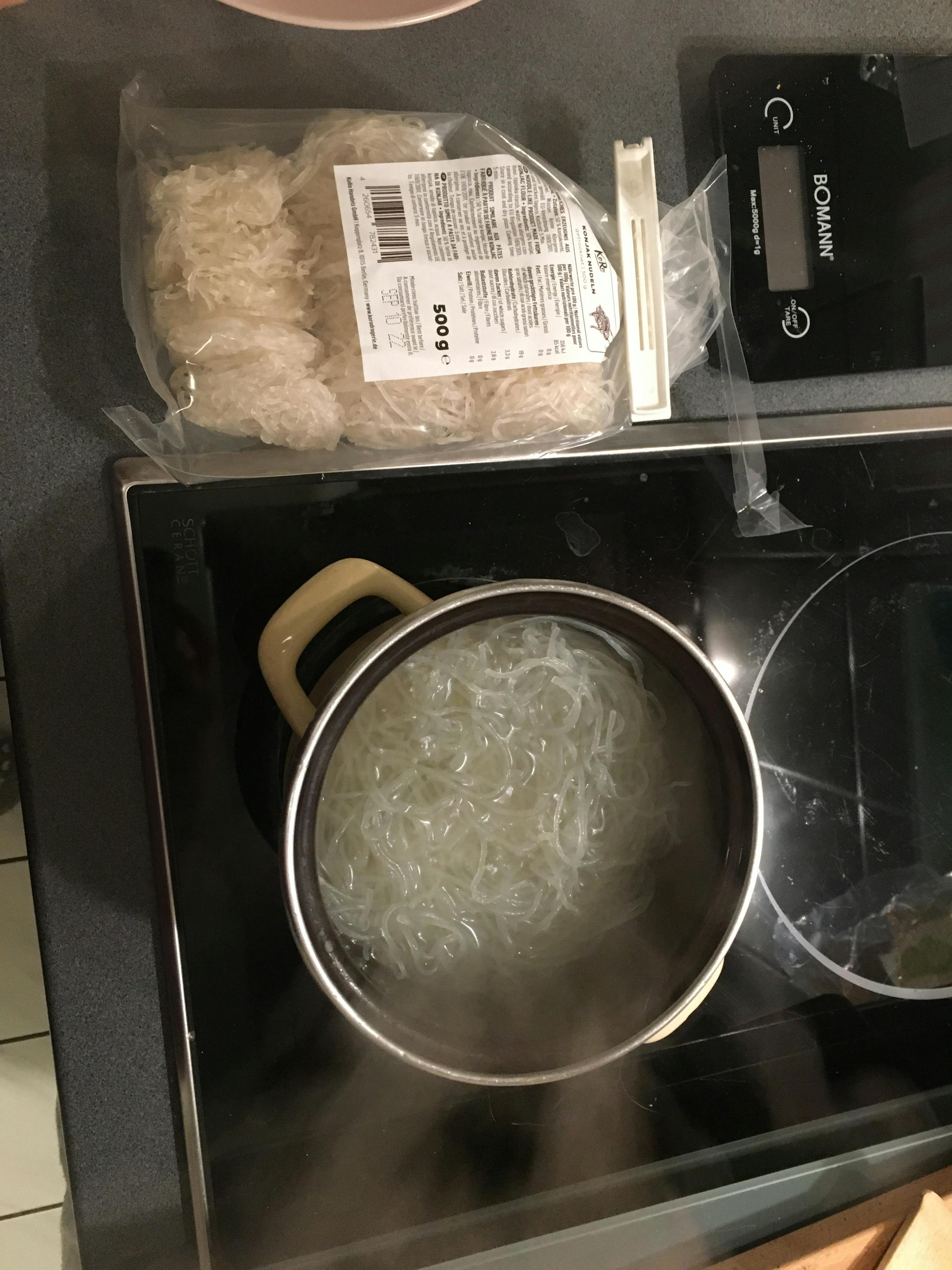 eine Bomann-Waage steht neben einem Topf mit Nudeln