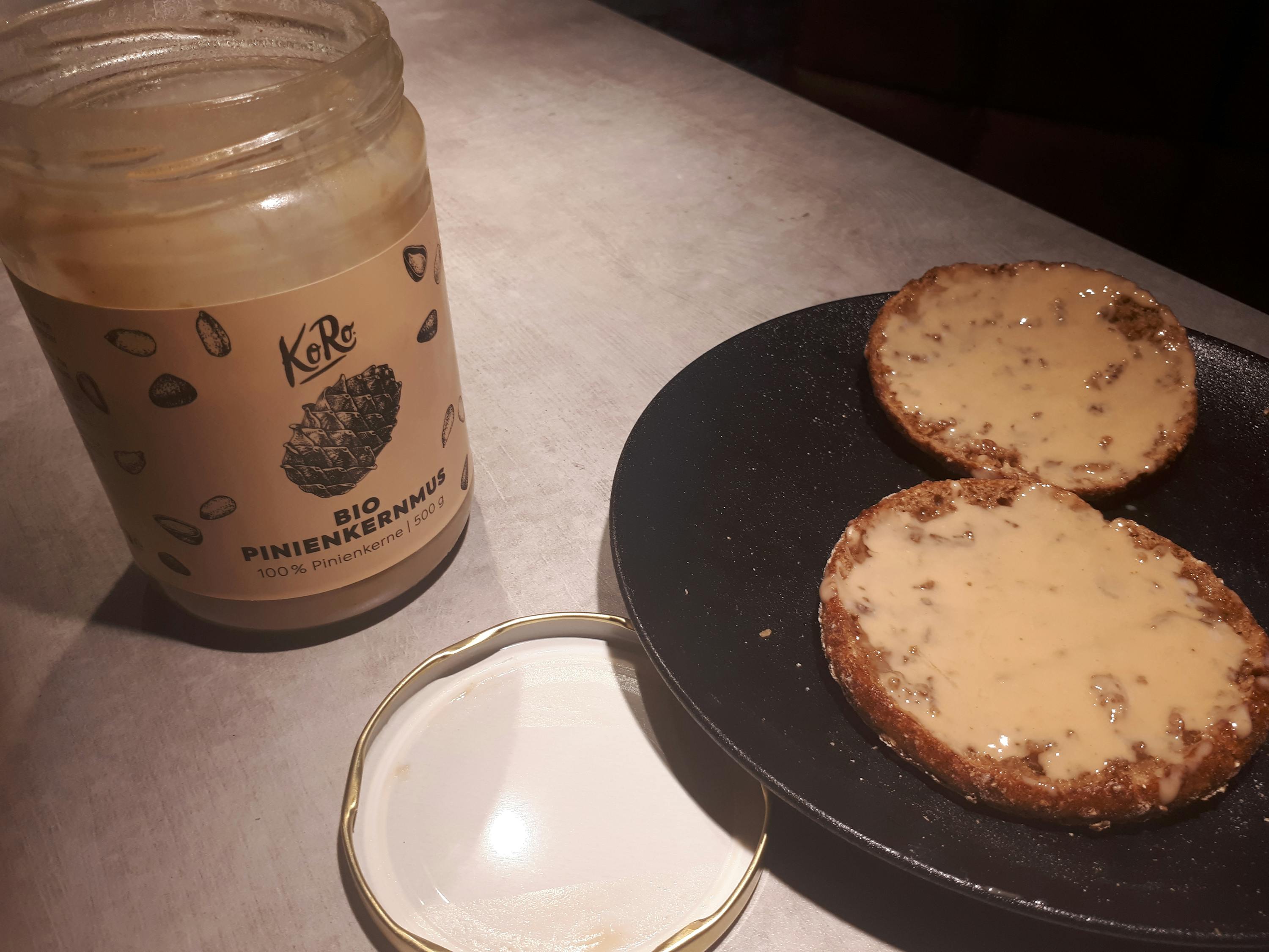 a jar of bio pinienkernermus next to a plate of food