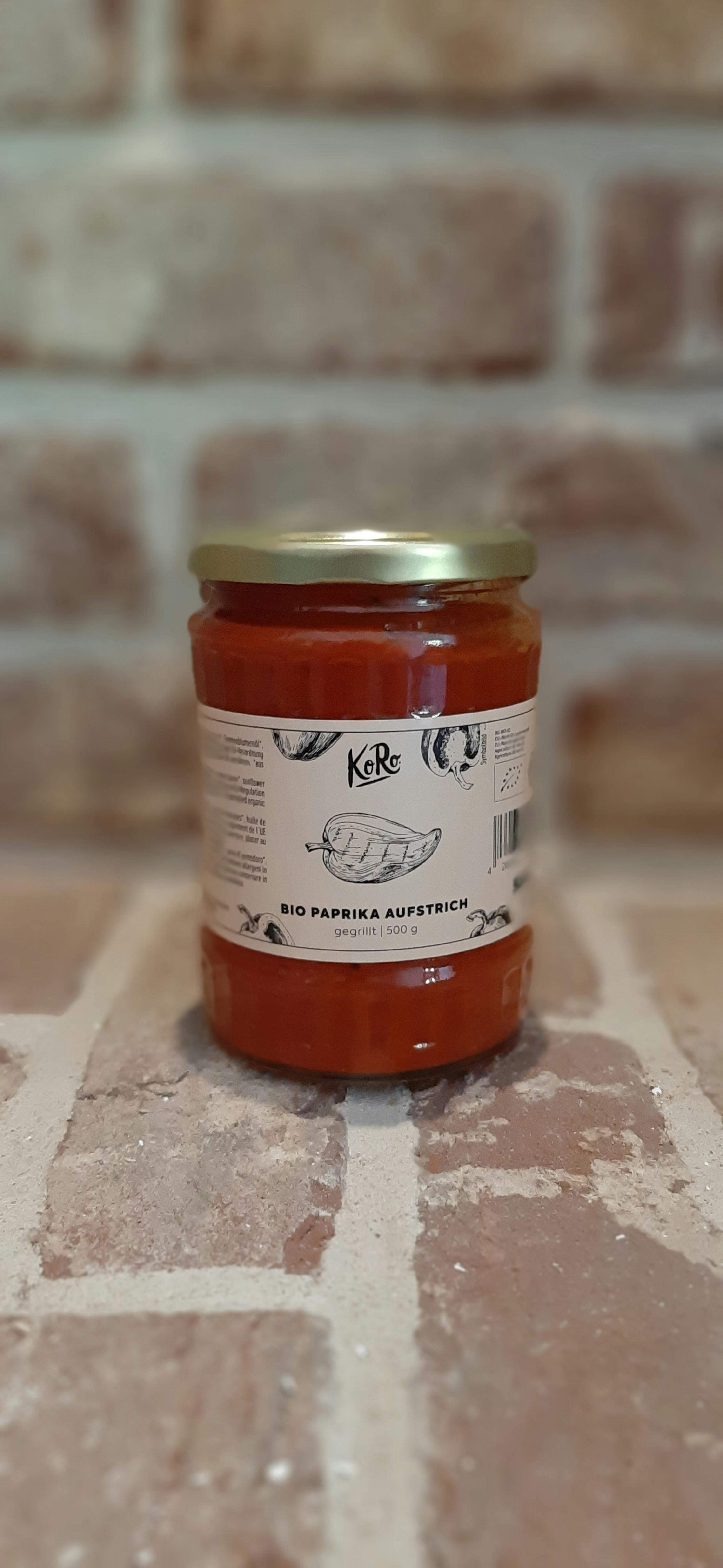 un bocal de paprika bio est posé sur un mur de briques