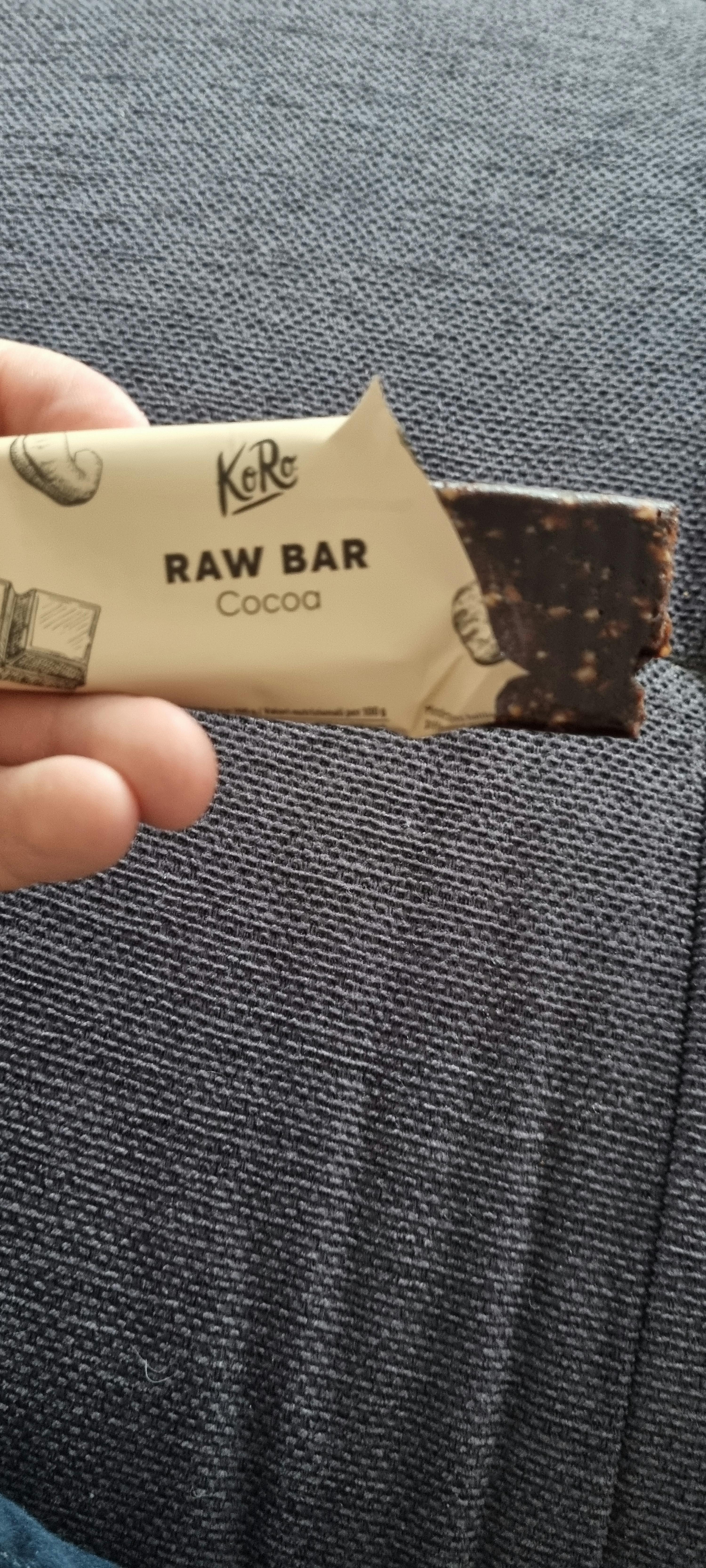 a person holding a raw bar with a bite taken out of it