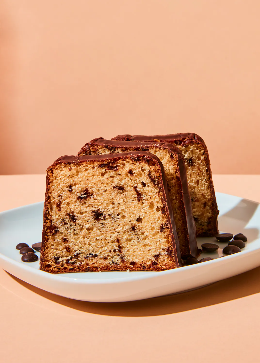 un morceau de gâteau avec des pépites de chocolat sur une assiette blanche