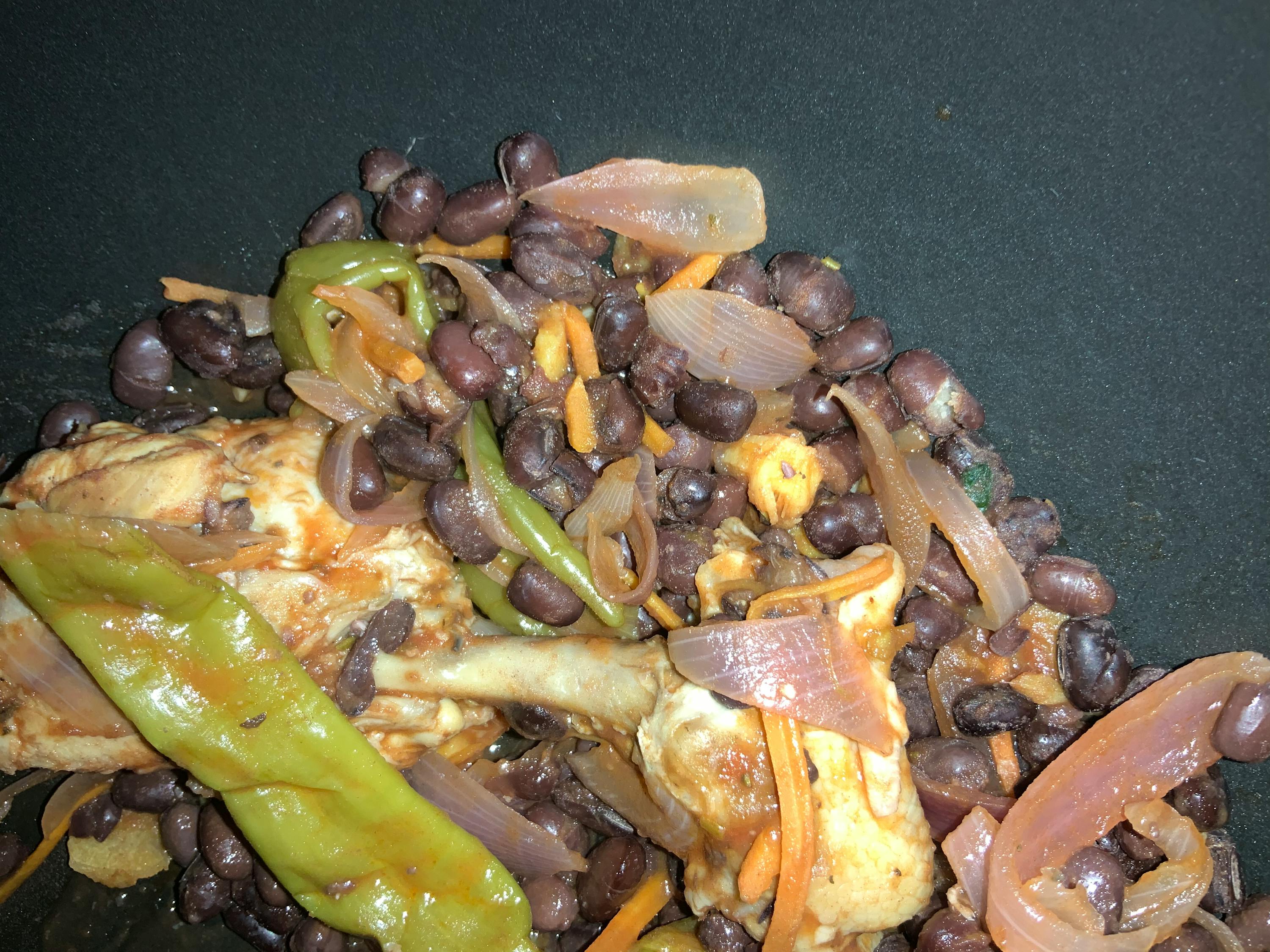 a chicken stew with black beans peppers and onions