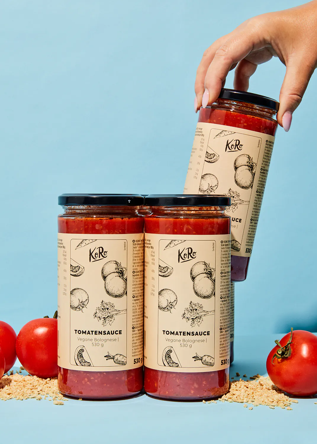 four jars of tomato sauce with a hand reaching for one