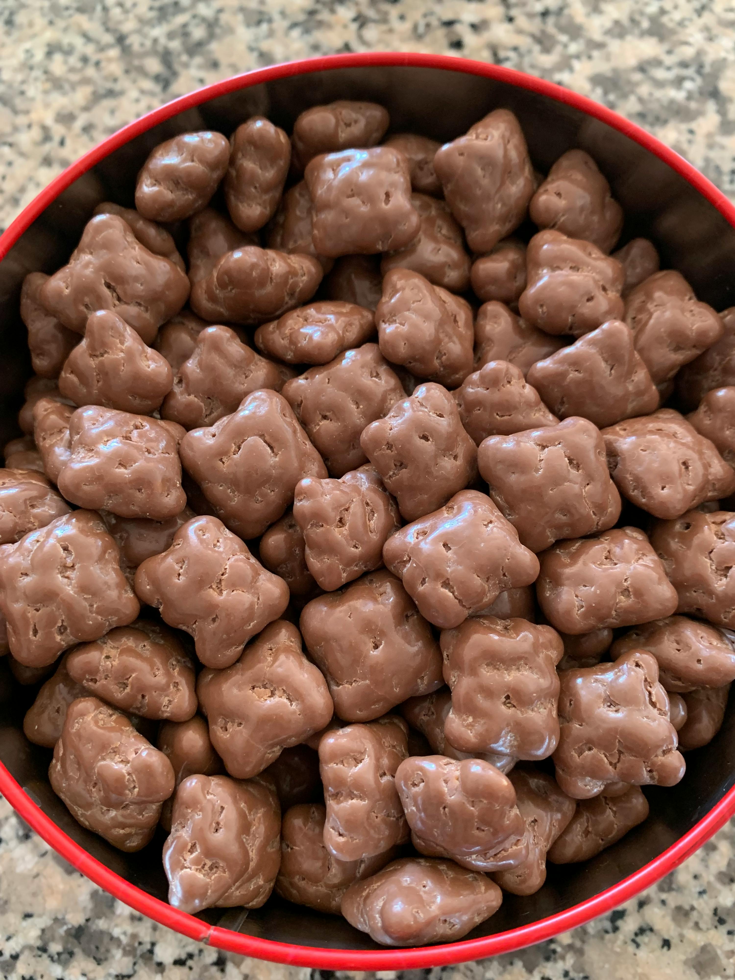 a red bowl filled with chocolate covered pretzels