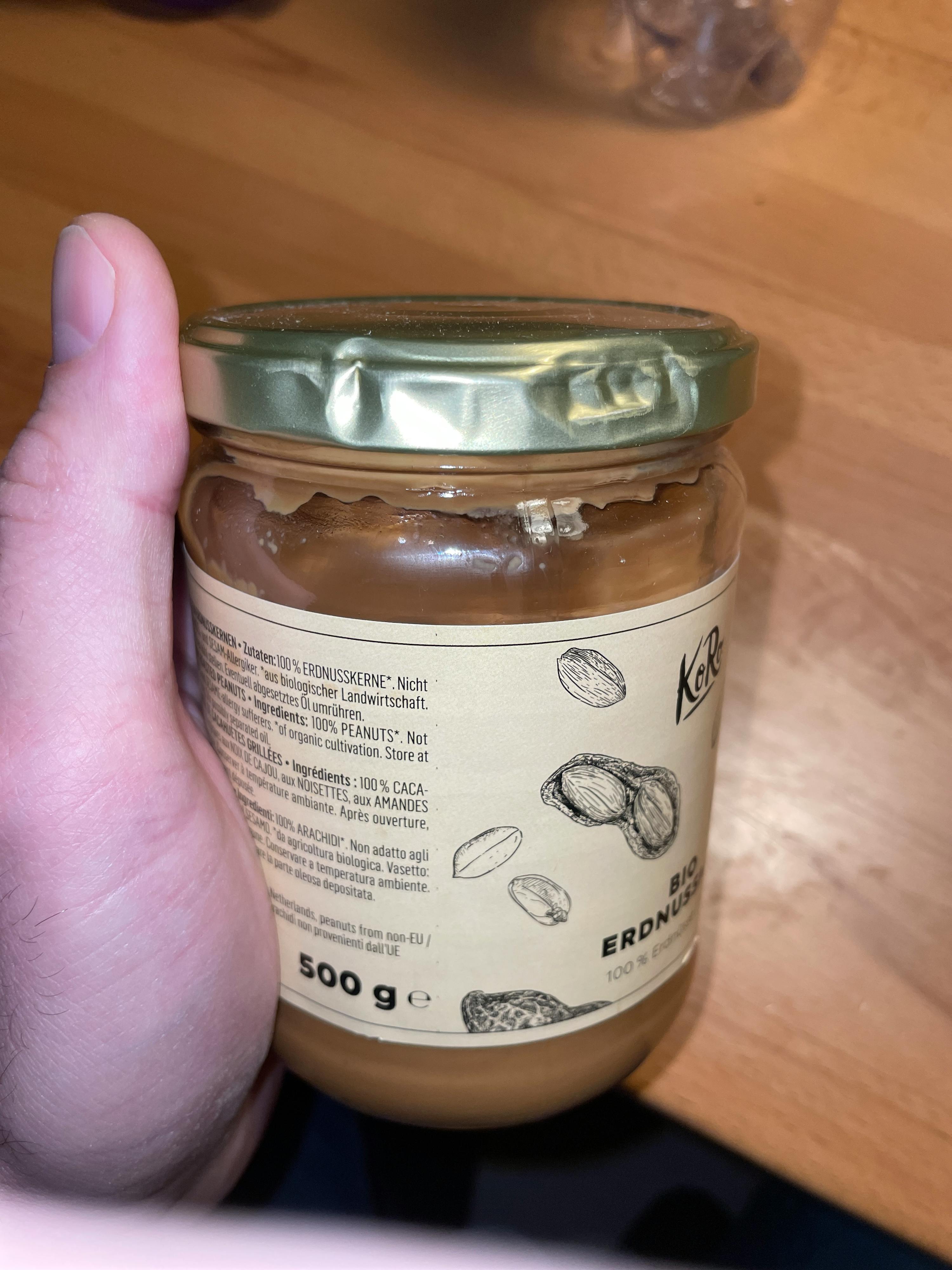 a person is holding a jar of peanut butter that is 500g