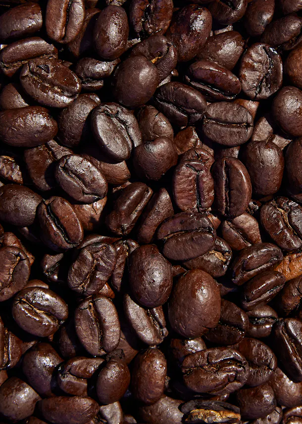 ein Haufen gerösteter Kaffeebohnen auf einem Tisch