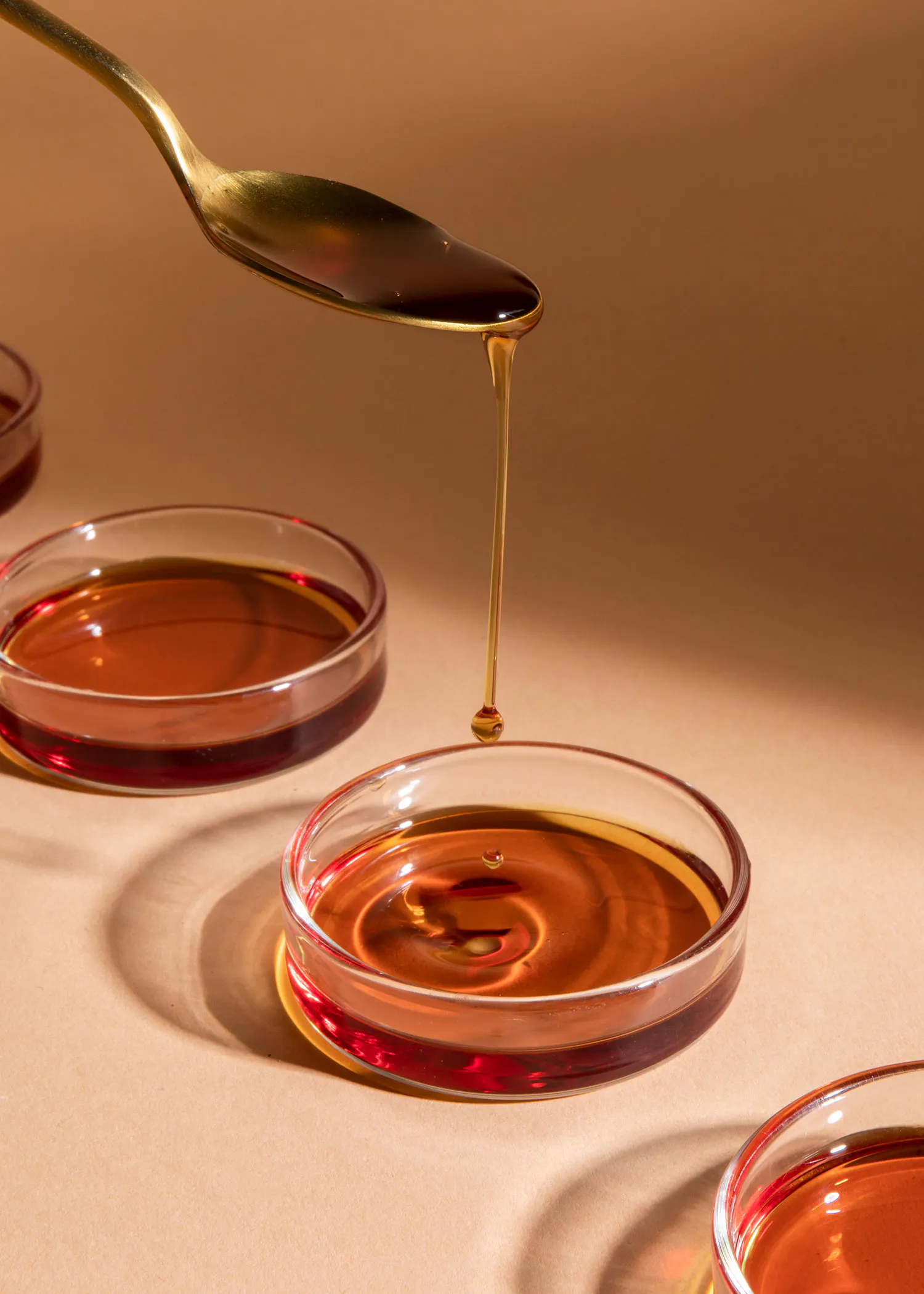 a spoon is pouring liquid into a small bowl