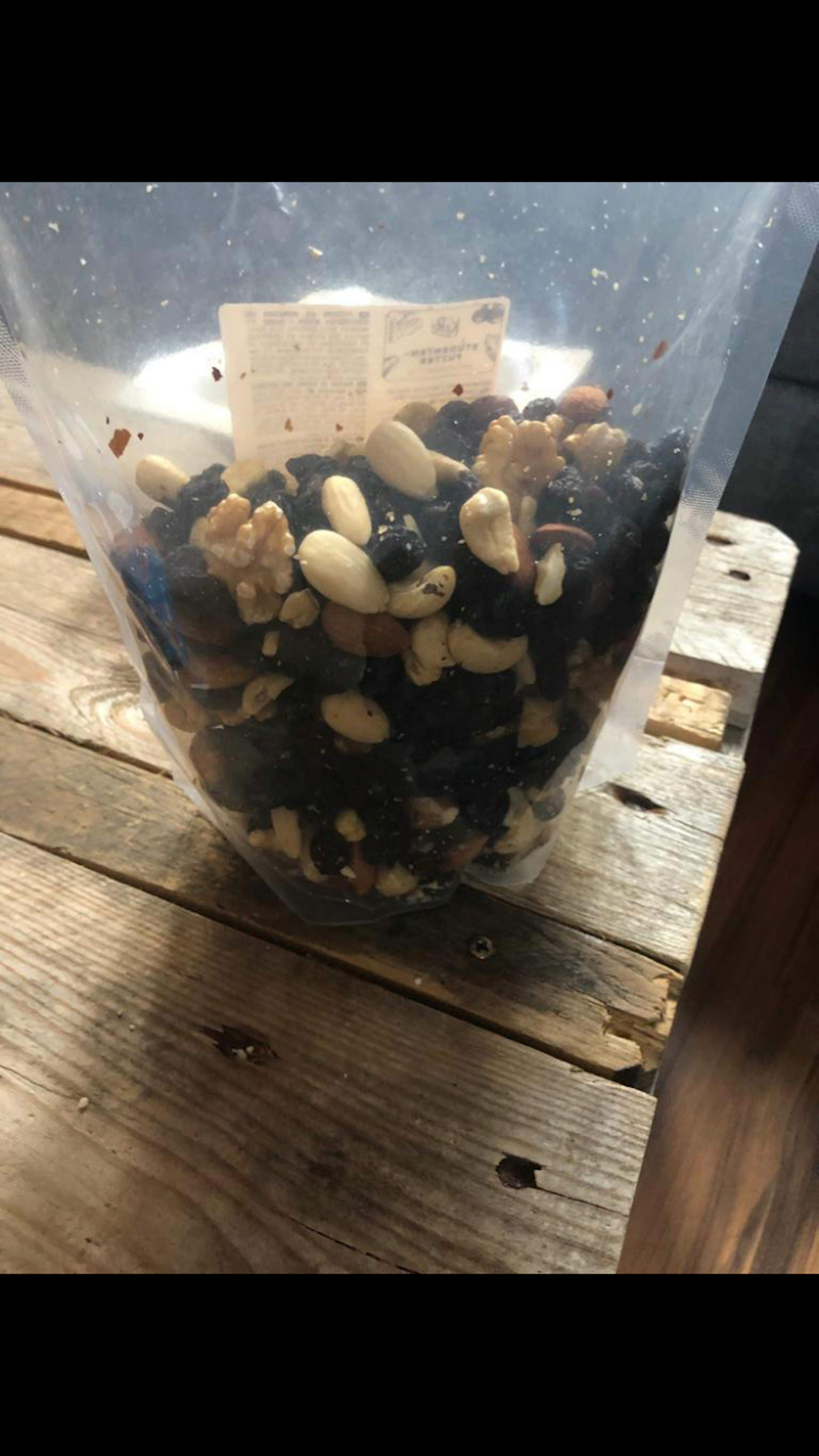 un sacchetto di frutta secca è seduto su un tavolo di legno