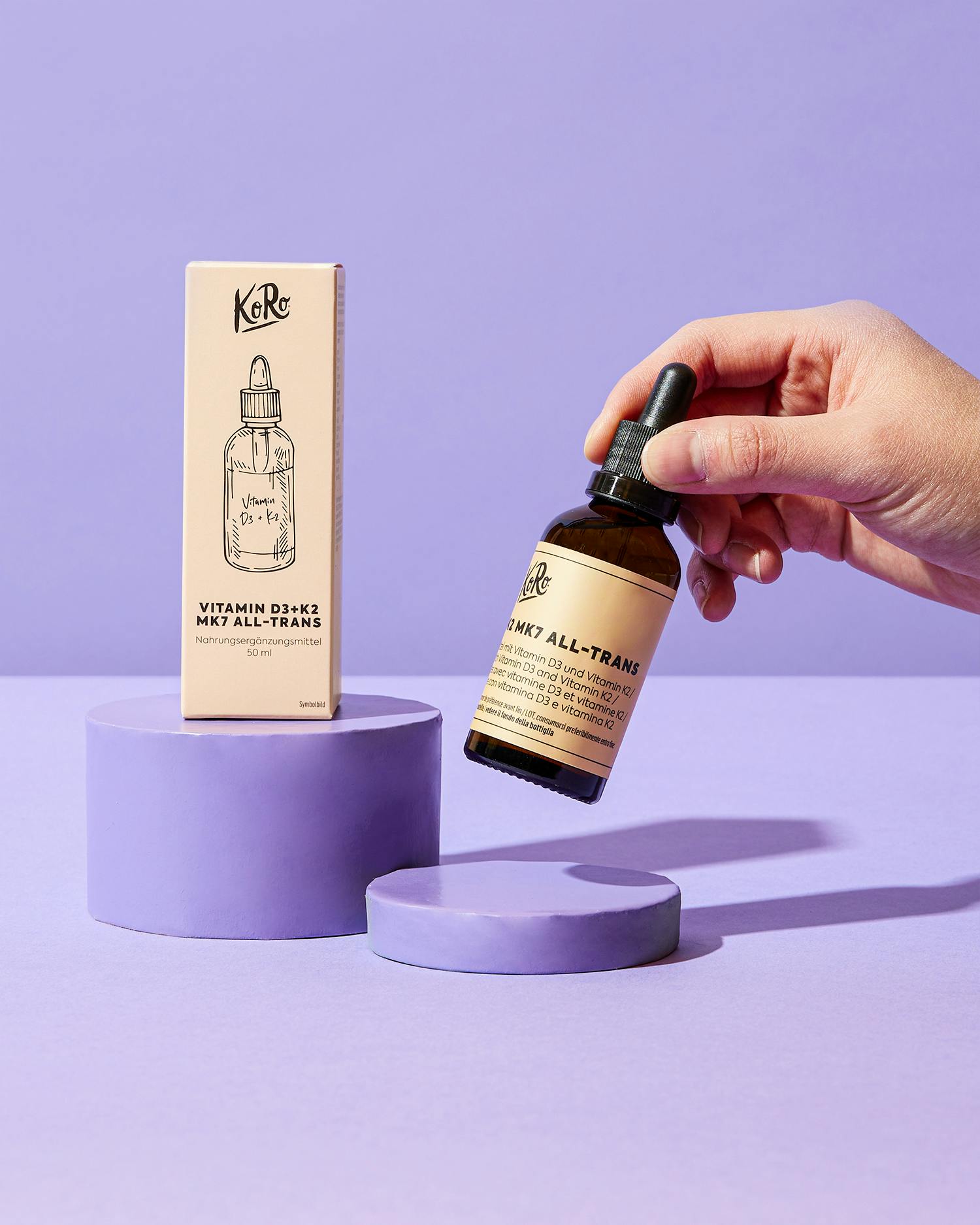 una persona tiene in mano una bottiglia di vitamina d3 k2 mk7 all-trans