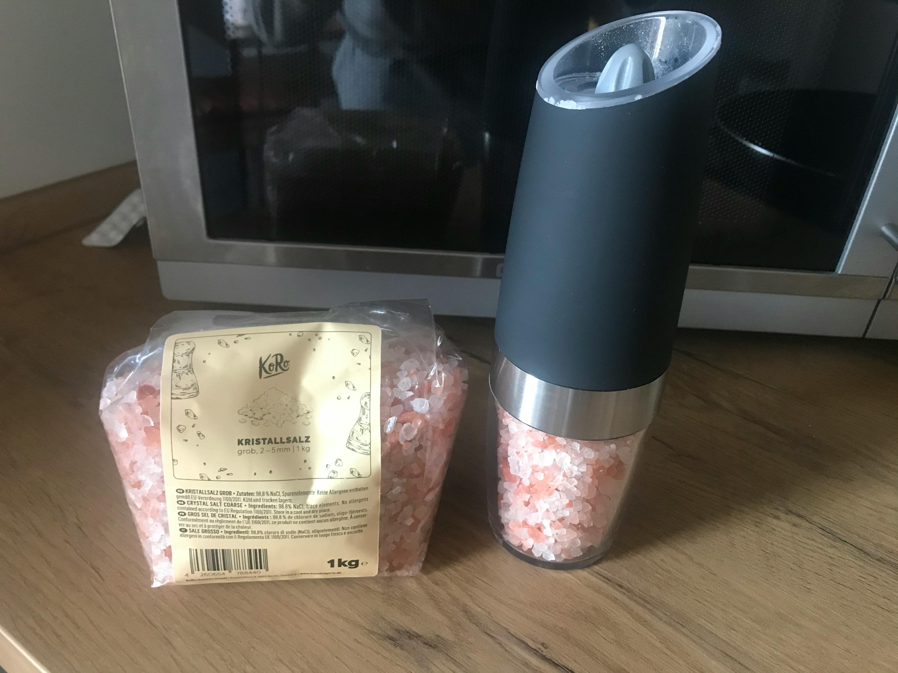eine Schachtel Kristallsalz steht neben einer Gewürzmühle