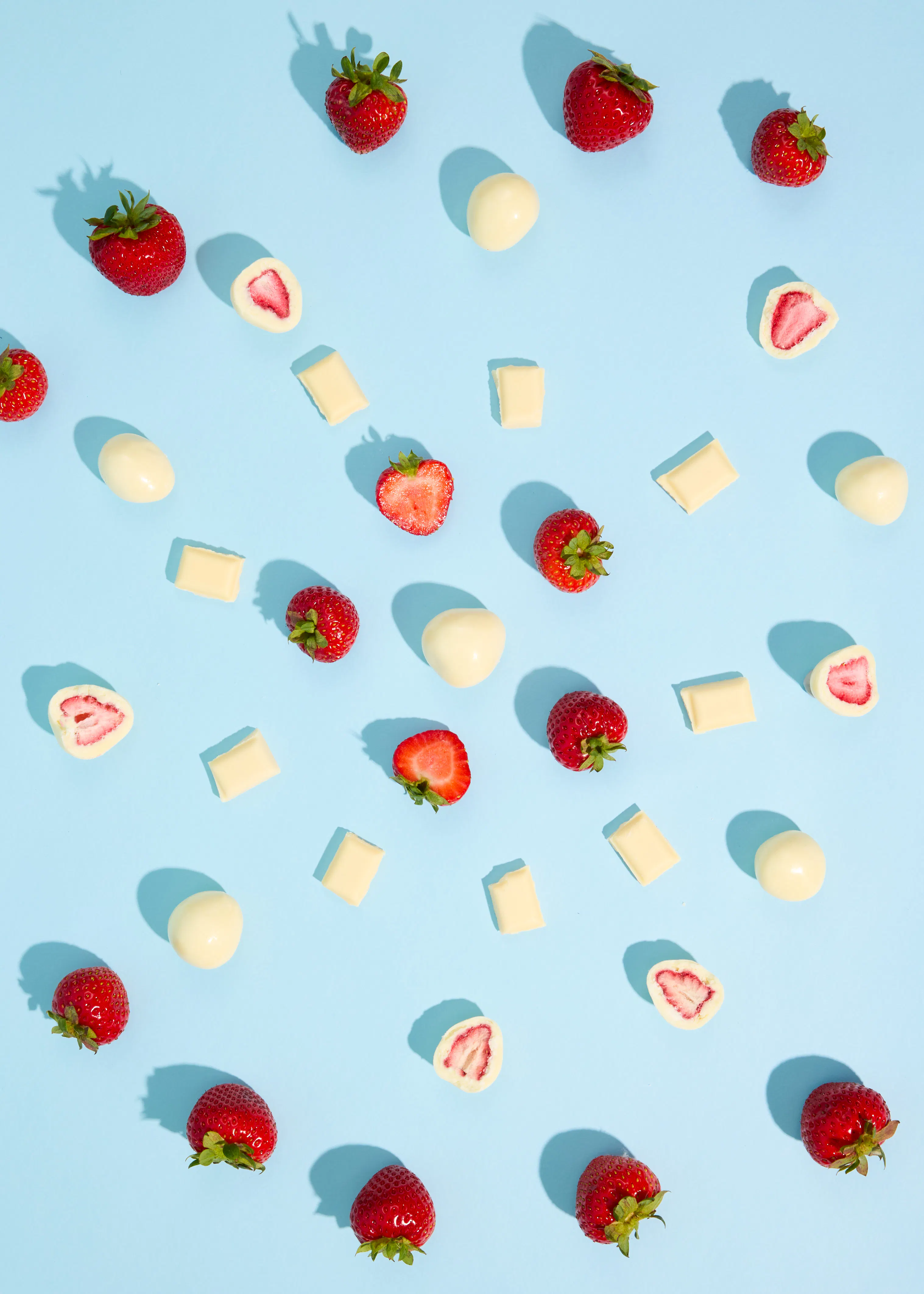 strawberries and white chocolate on a blue surface