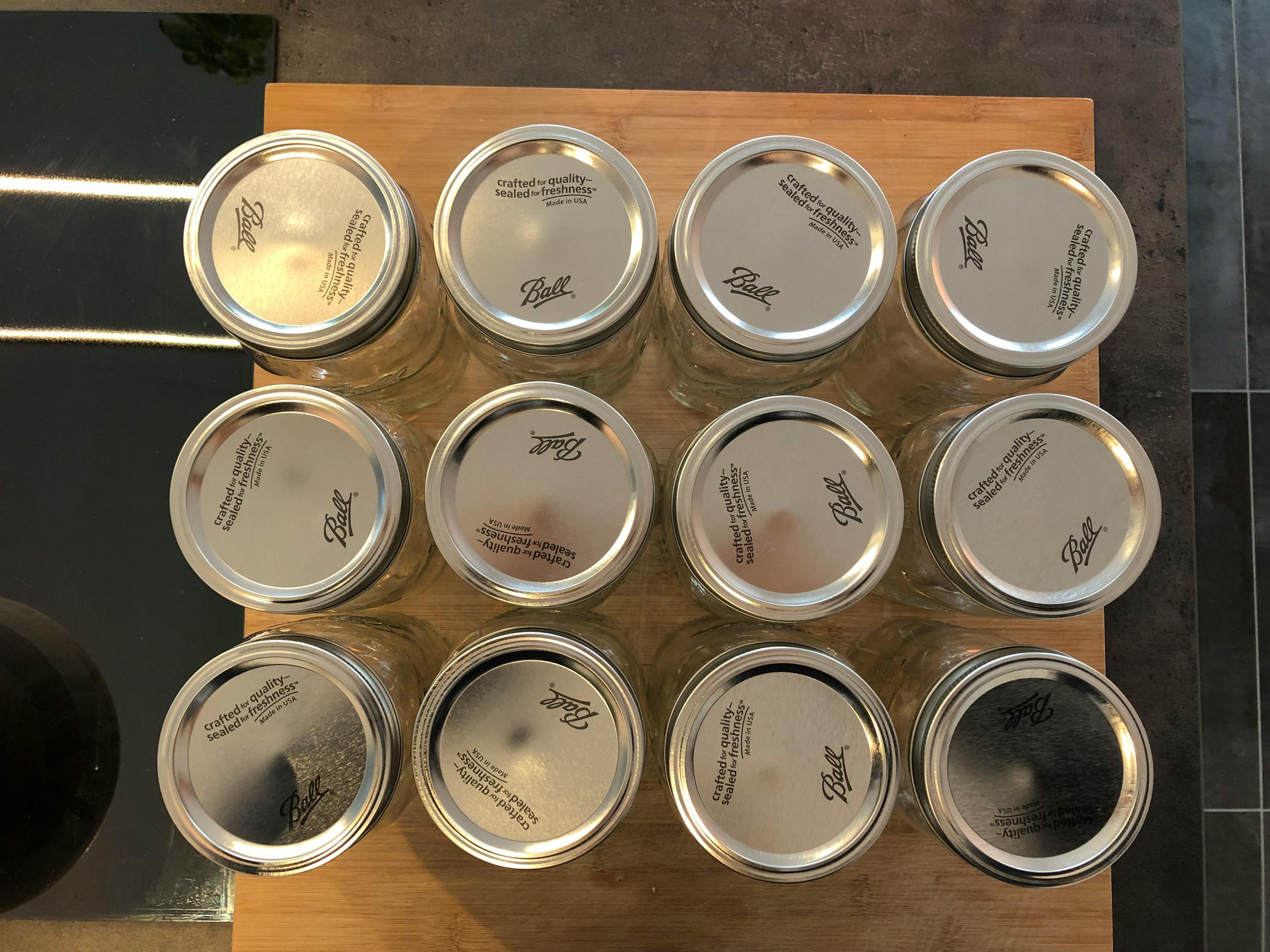 un tas de bocaux ball posés sur une planche à découper en bois