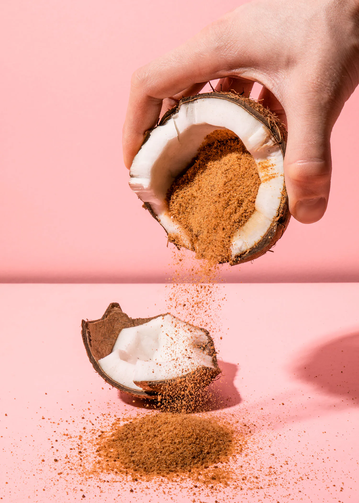 a person is pouring brown sugar from a coconut