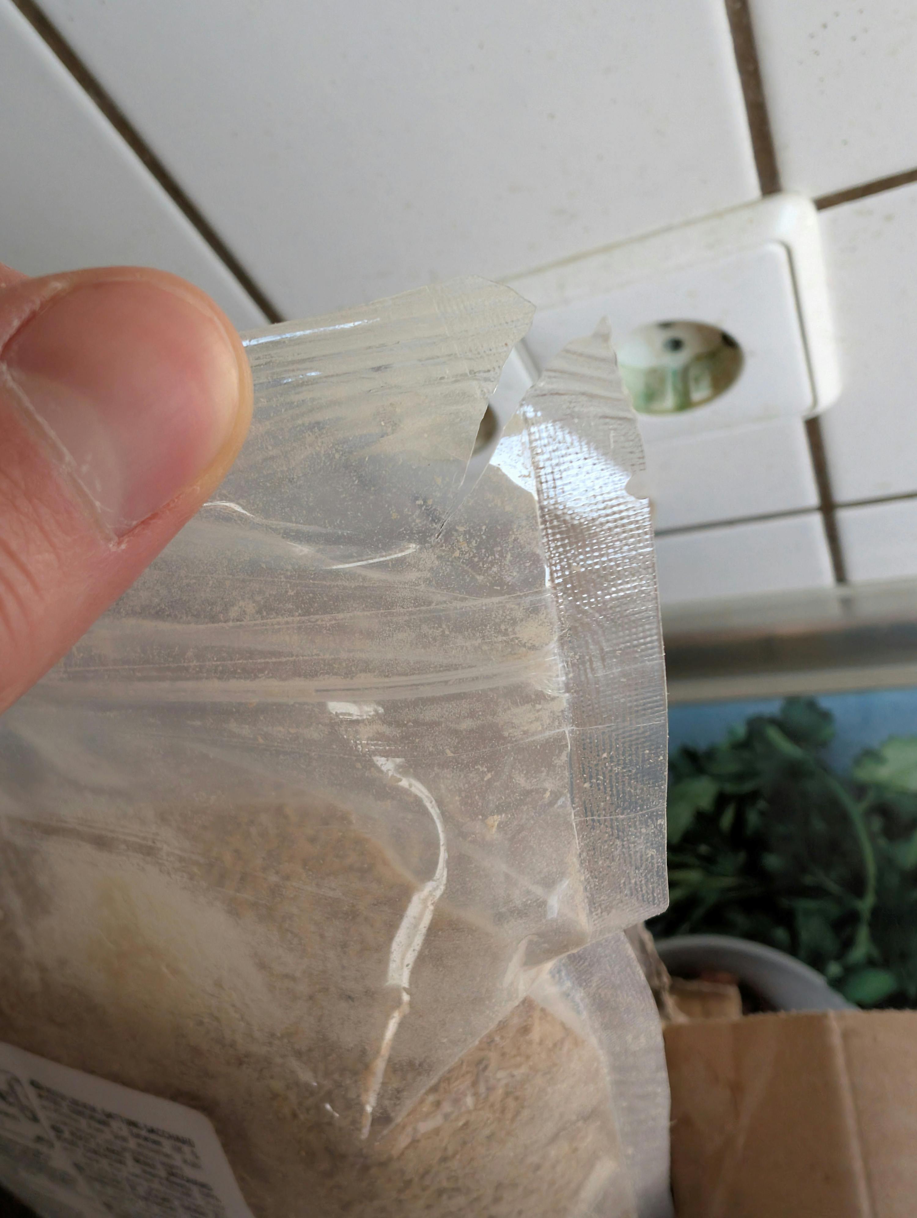 eine Person hält einen Plastikbeutel mit einem Stück Klebeband darauf