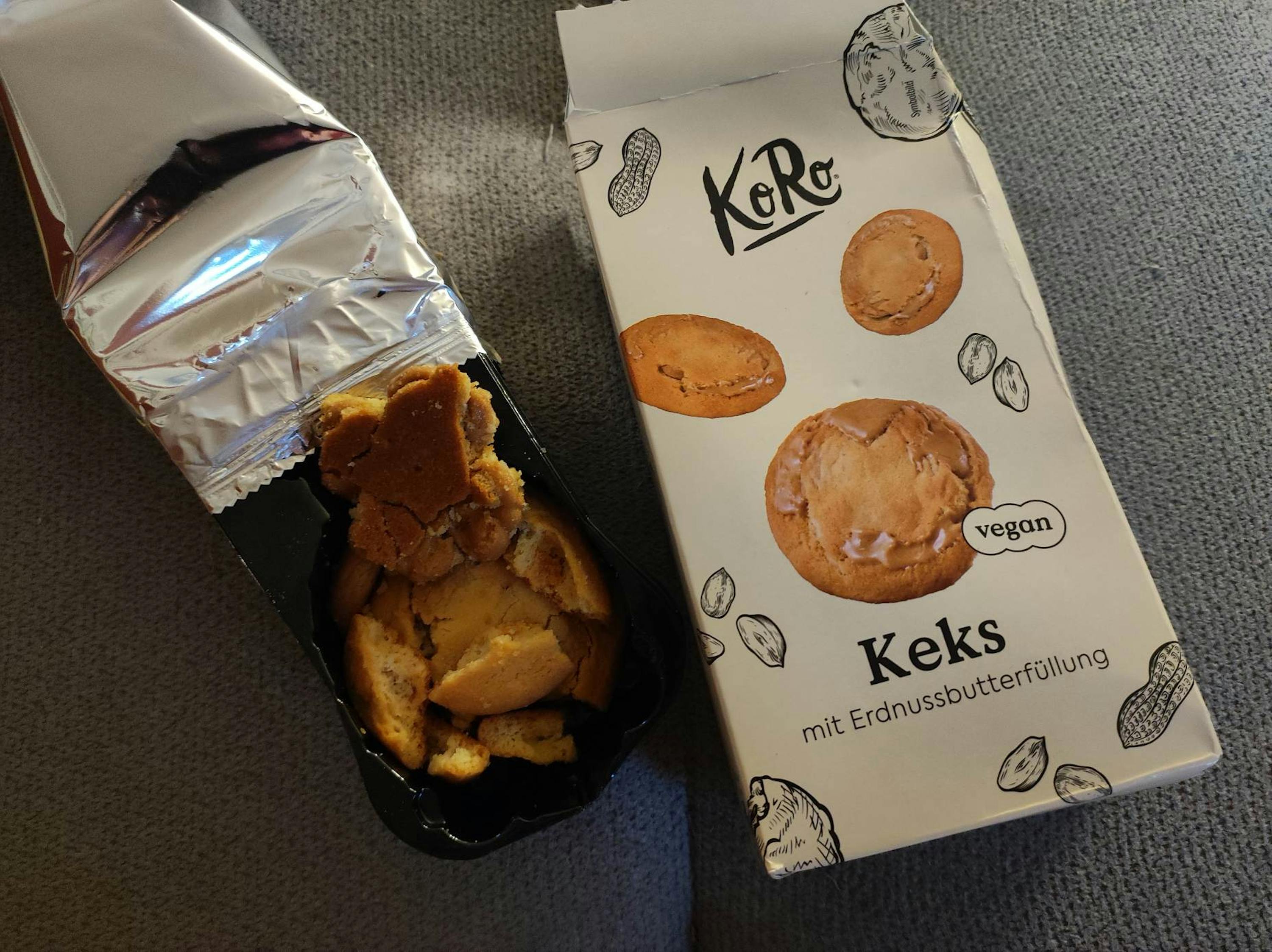 una scatola di biscotti vegani è seduta accanto a una scatola di biscotti rotti